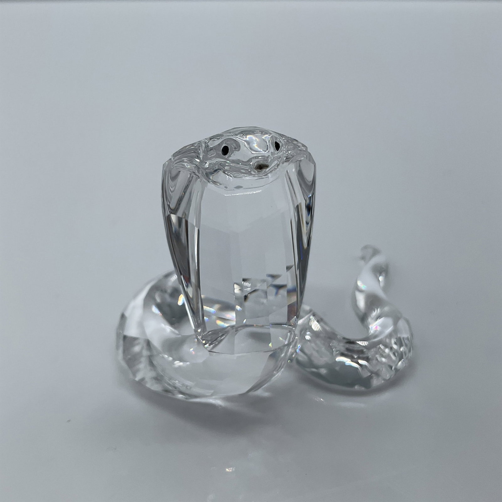 Swarovski Crystal Figurine, Cobra Snake: Lead crystal part of the African Wildlife collection and is made with a rhodium forked tongue, clear faceted crystal with the tail made up of two sections. Swarovski etched backstamp. This item has it