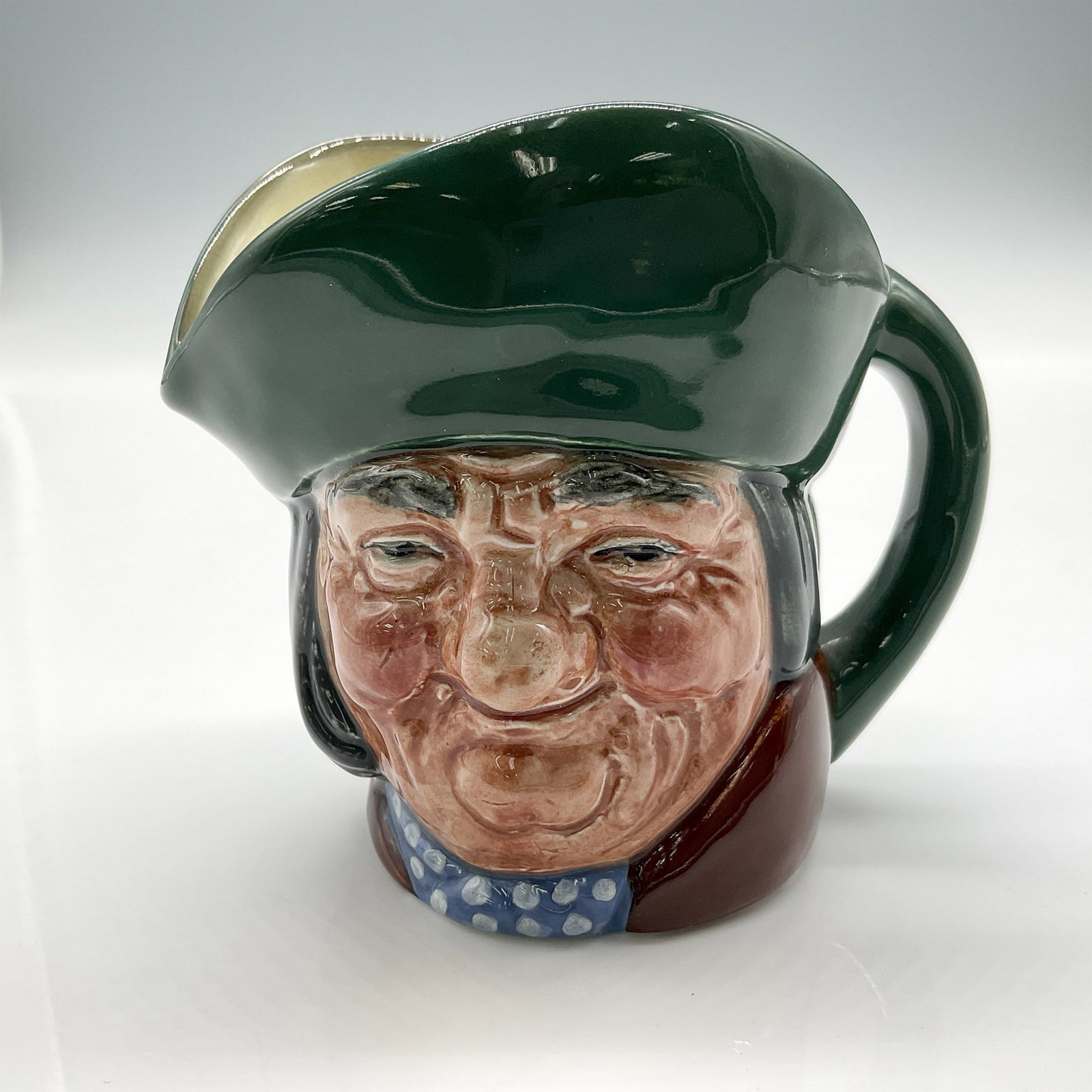Toby Philpots D5737 - Small - Royal Doulton Character Jug: Part of the English Heritage series, colored in green hat, brown coat, and blue scarf with white spots. Royal Doulton backstamp. Artist: Charles Noke Issued: 1937 - 1969 Dimensions: 3.5"L x 2.75"W x 3