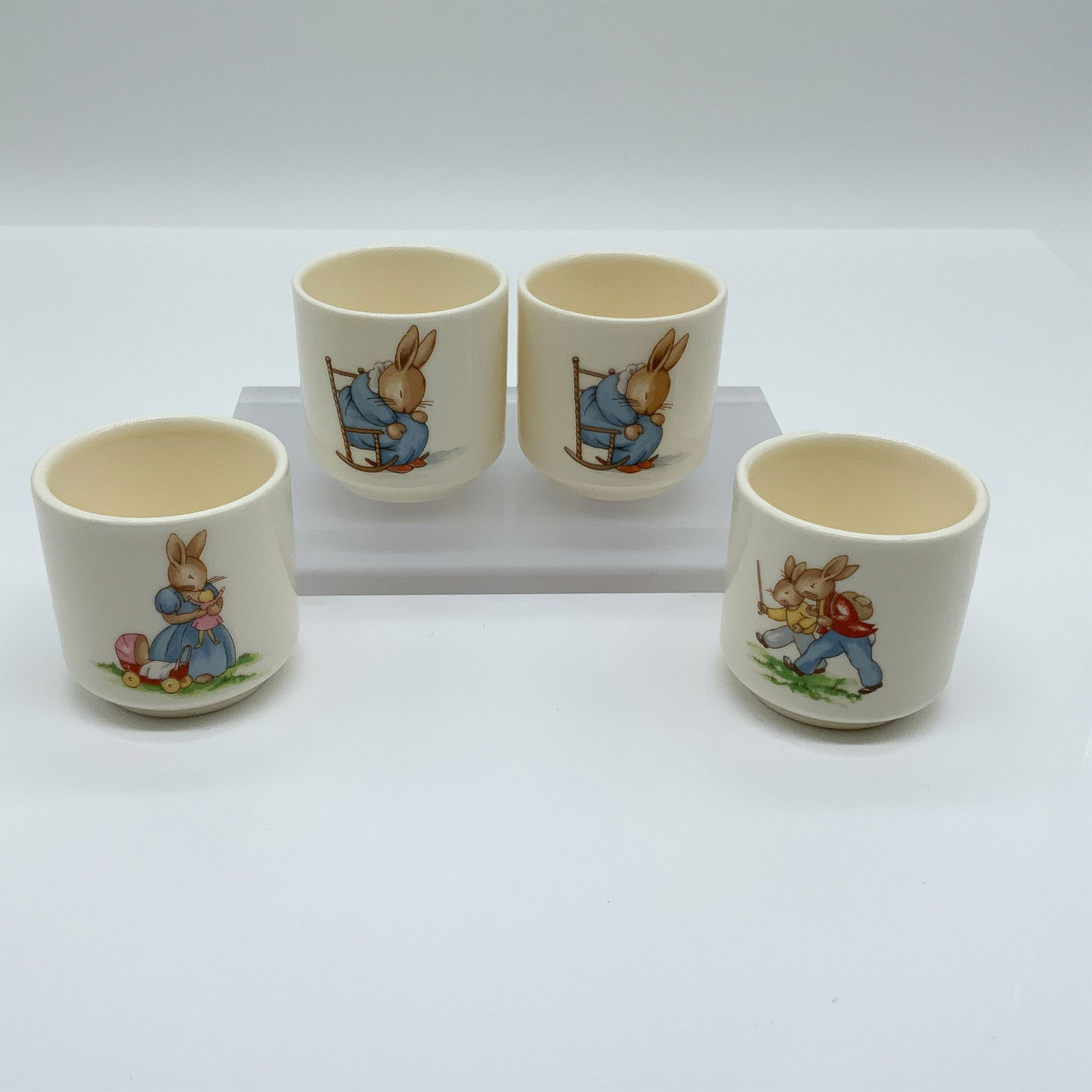 Royal Doulton Bunnykins, 4-Piece Egg Cup Set: This delightful set of four Royal Doulton Bunnykins egg cups features hand-painted scenes of the iconic Bunnykins characters, each in a different whimsical pose. The designs capture the playful charm