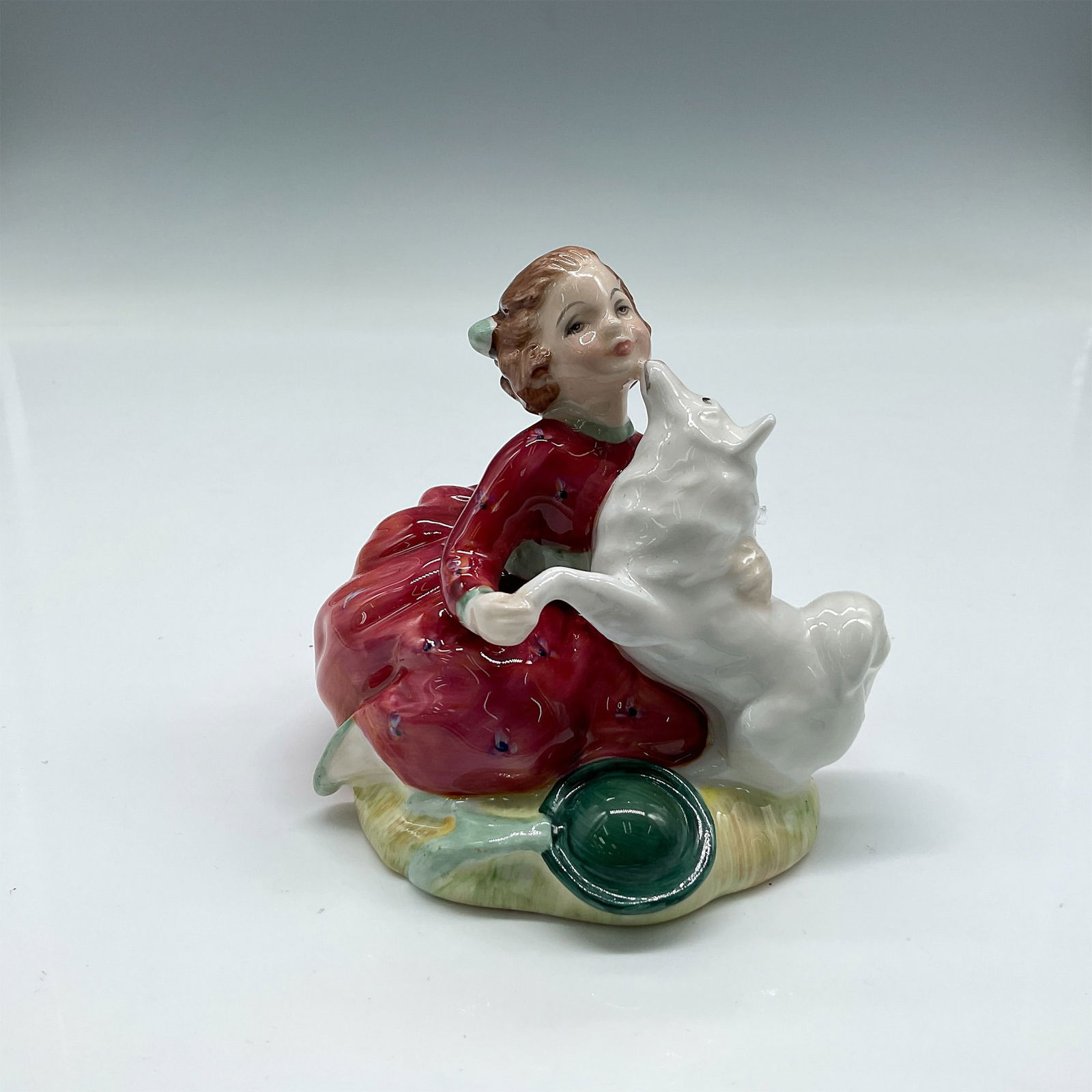 Royal Doulton Bone China Figurine, Home Again HN2167: Part of the Child Study Series, young figure with her dog, colored in red and white. Royal Doulton backstamp. Artist: Peggy Davies Issued: 1956 - 1995 Dimensions: 3.75"L x 3.25"W x 3.25"H Country of O