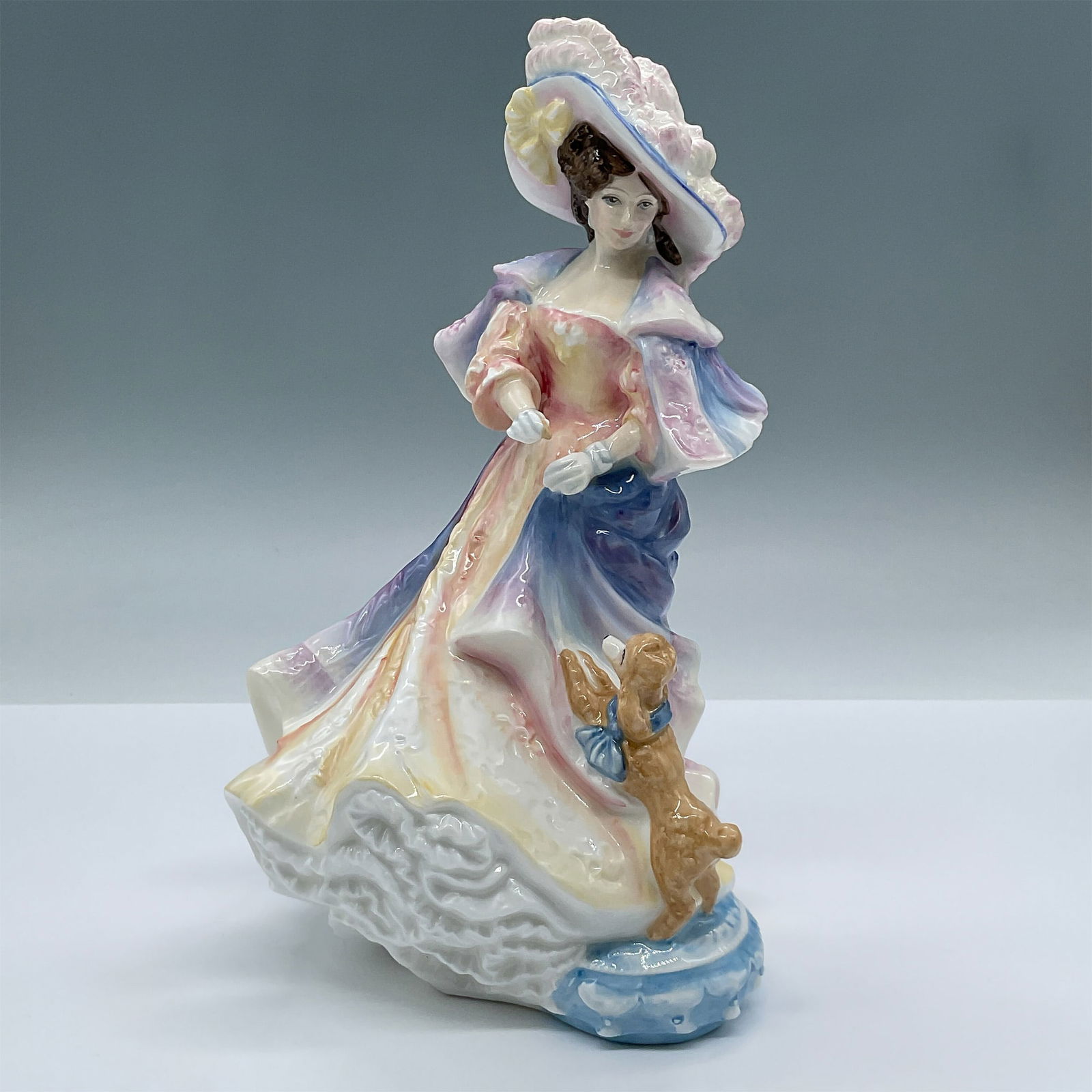 Royal Doulton Bone China Figurine, Katherine HN3708: From the Lady Doulton series, features like lovely woman in a lavish dress and feathered hat, handing a treat to a small poodle. Royal Doulton backstamp. Artist: Valerie Annand Issued: 1996 Dimensions