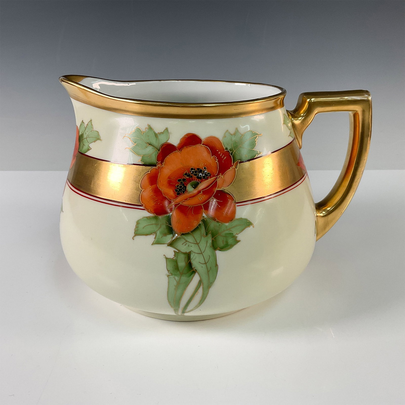 Heinrich & Co. by Howard Reury Poppy Design Jug: Elegant Heinrich & Co. porcelain jug featuring a hand painted poppy motif by renowned porcelain artist Howard Reury. The jug showcases vibrant orange poppies with lush green foliage, accented by a ric