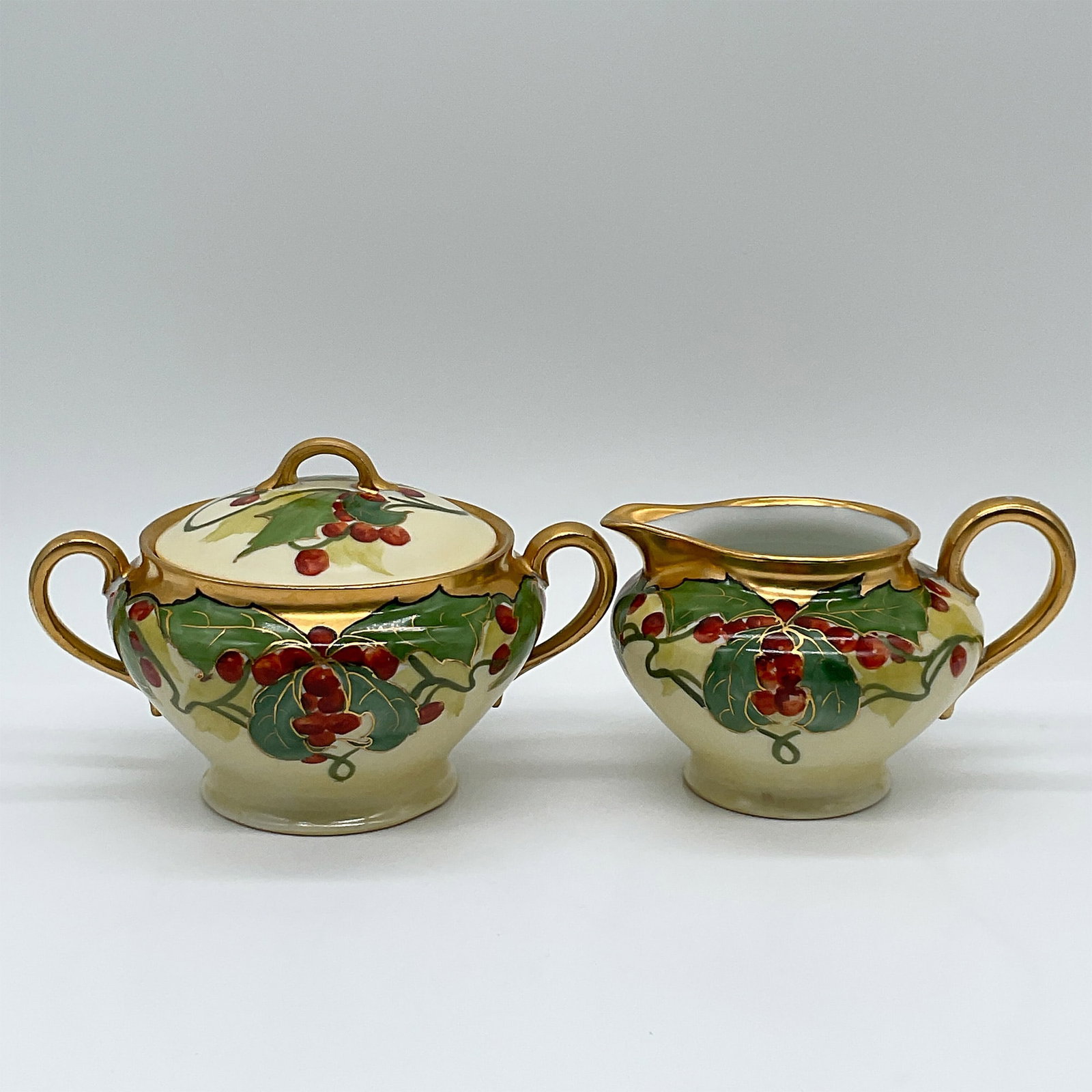 GDA France Porcelain Cream and Sugar Set, Holly Design: Elegant GDA France porcelain cream and sugar set featuring a hand-painted holly and berries design. This festive set includes a lidded sugar bowl and a creamer jug, each adorned with vibrant red berri