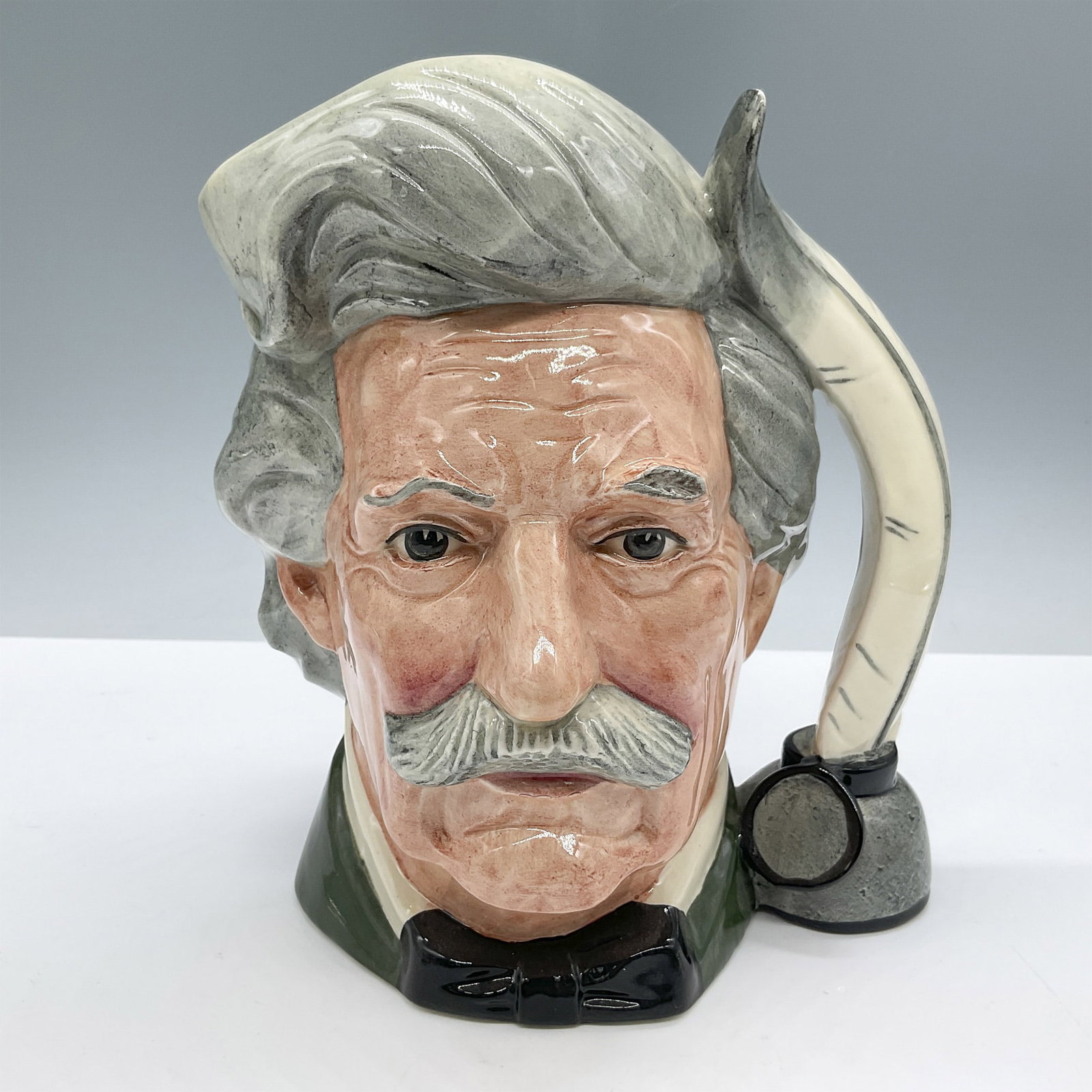 Mark Twain D6654 - Large - Royal Doulton Character Jug: Black coat and bow tie, grey hair. Royal Doulton backstamp. Artist: Eric Griffiths Issued: 1980 - 1990 Dimensions: 6.5''L x 5.5''W x 6.5''H Country of Origin: England