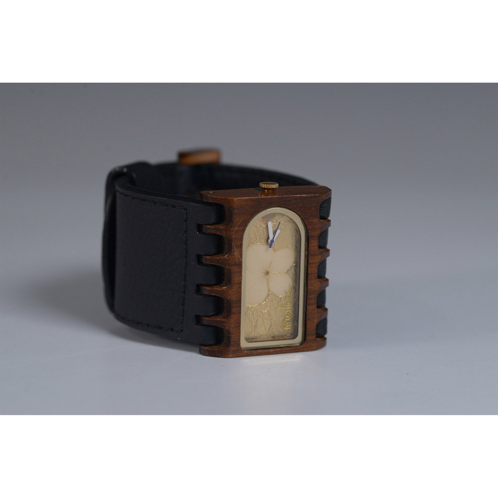 Mistura Wooden Watch with Floral Detail and Leather Band: This unique Mistura wooden watch features a rectangular wood case with a delicate floral detail inside the face. The watch is crafted from Colombian fine woods, paired with a durable leather band. It 