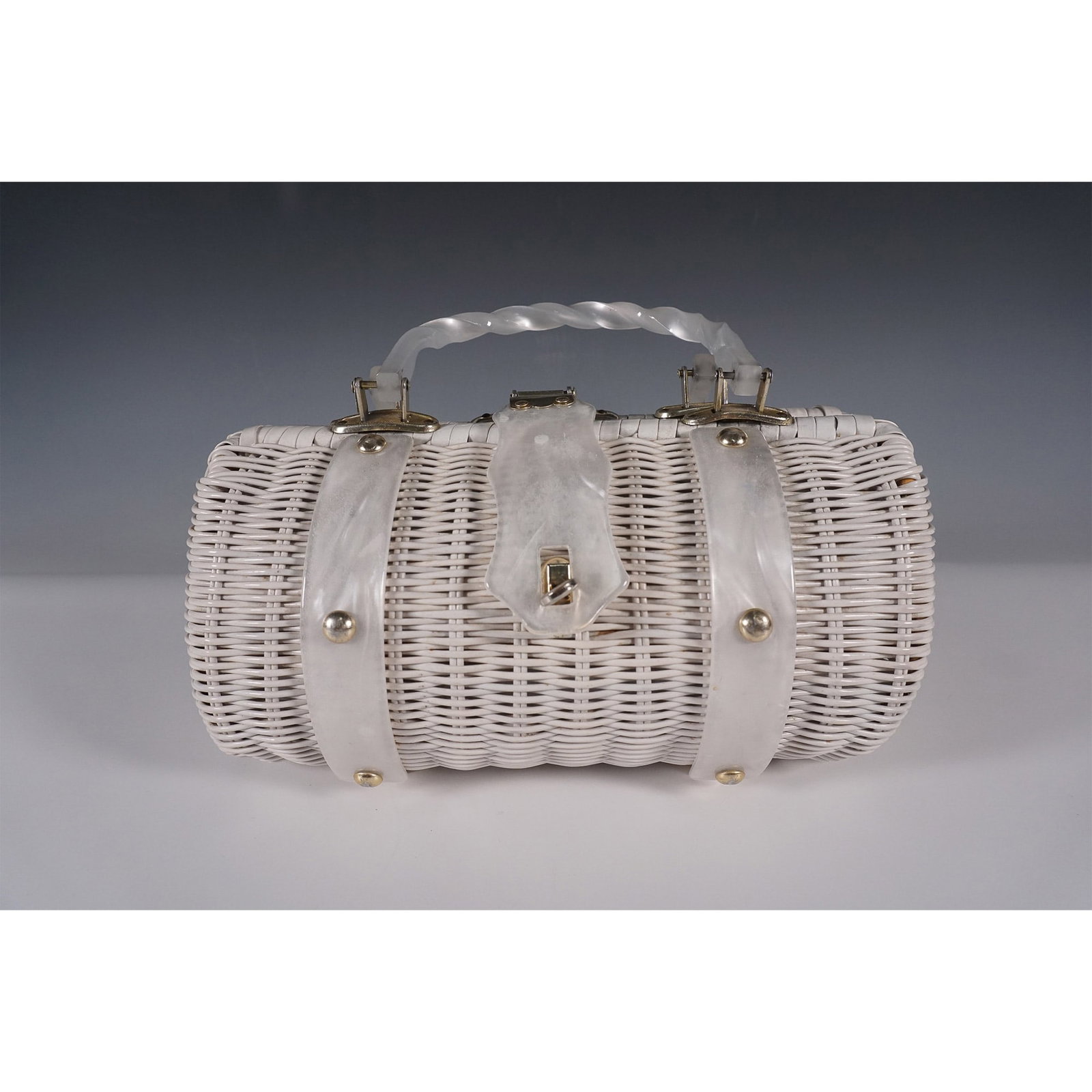 Vintage White Wicker Barrel Handbag: Charming vintage white wicker handbag in a barrel shape, featuring a glossy woven exterior, pearlized lucite handles, and gold-tone hardware. The structured design includes a hinged frame with a secur