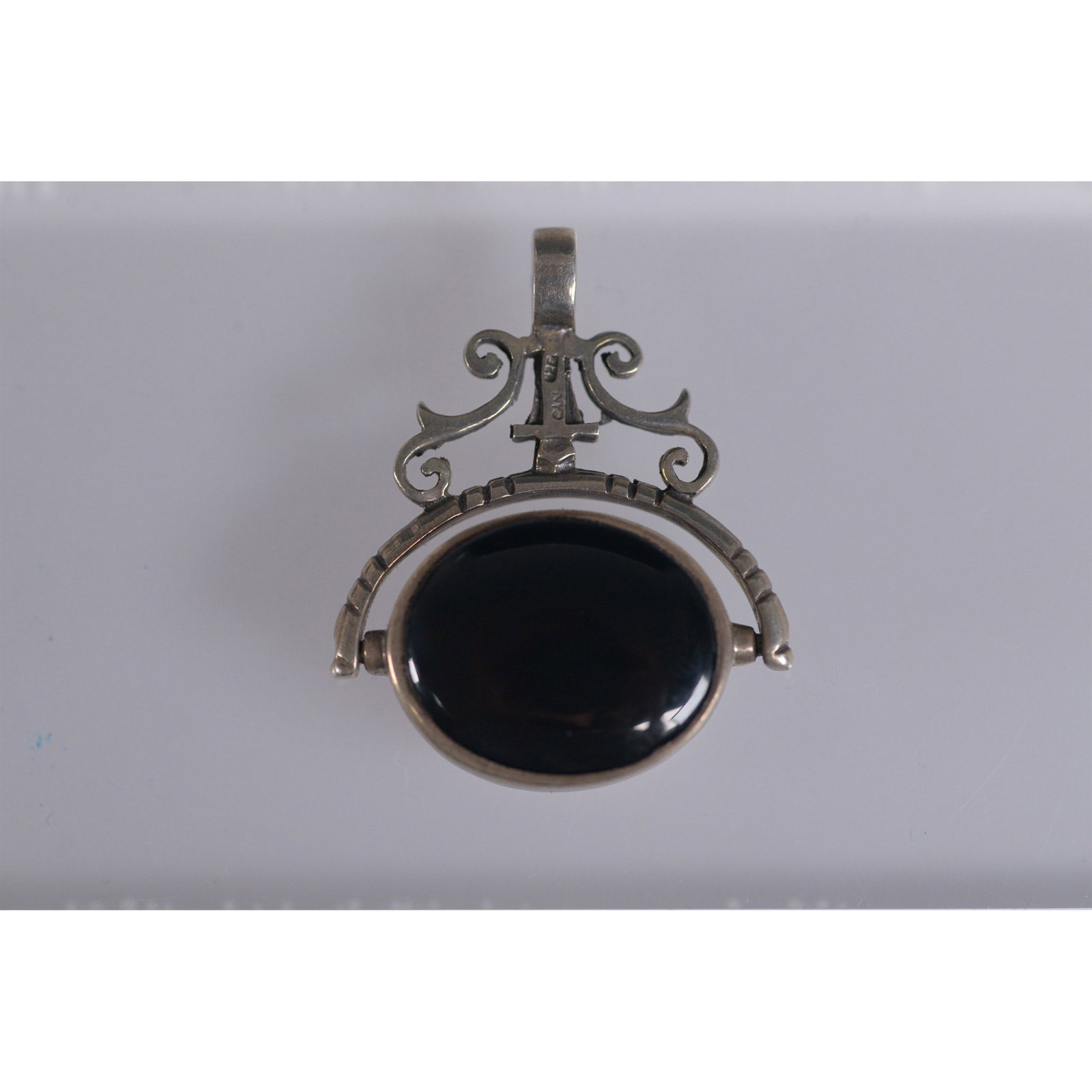 Sterling Silver Flip Pendant, Onyx and Pearlescent Stones: Elegant silver flip pendant featuring a reversible design with one side showcasing a polished black onyx stone and the other a pearlescent pinkish stone. The stones are set in a 925 silver mounting wi