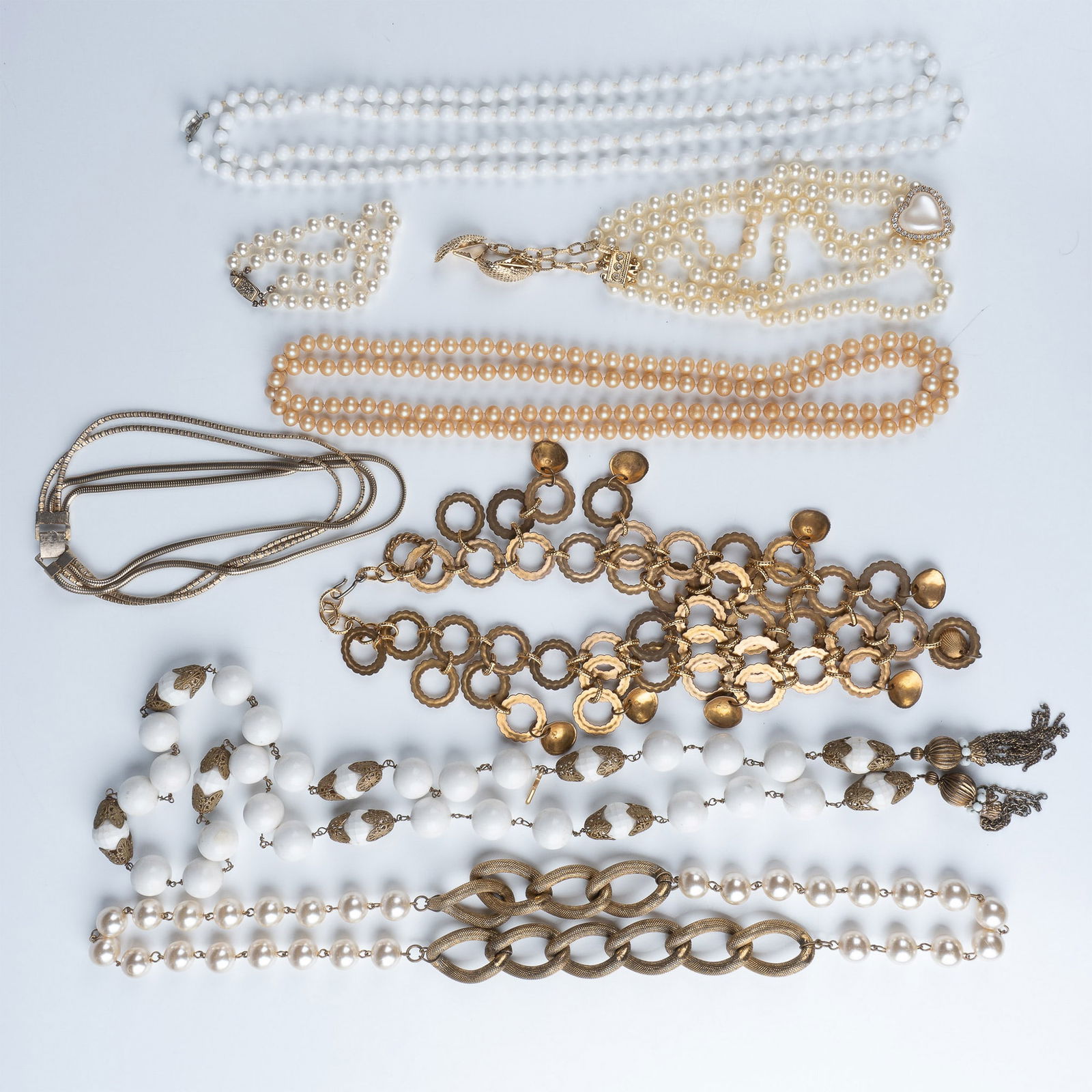 Vintage Jewelry Collection, Assorted Necklaces and Bracelets: An elegant collection of nine vintage jewelry pieces, including an assortment of necklaces and bracelets in gold-tone metal, faux pearls, and white beaded designs. This curated selection showcases a m