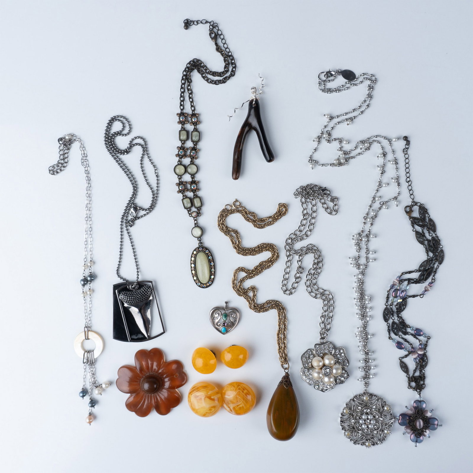 12pc Vintage Necklaces, Pendants and Earrings: This auction lot features an array of vintage jewelry pieces. The first is a vintage Bakelite pendant necklace, showcasing the rich and iconic material known for its vibrant color and distinctive desi