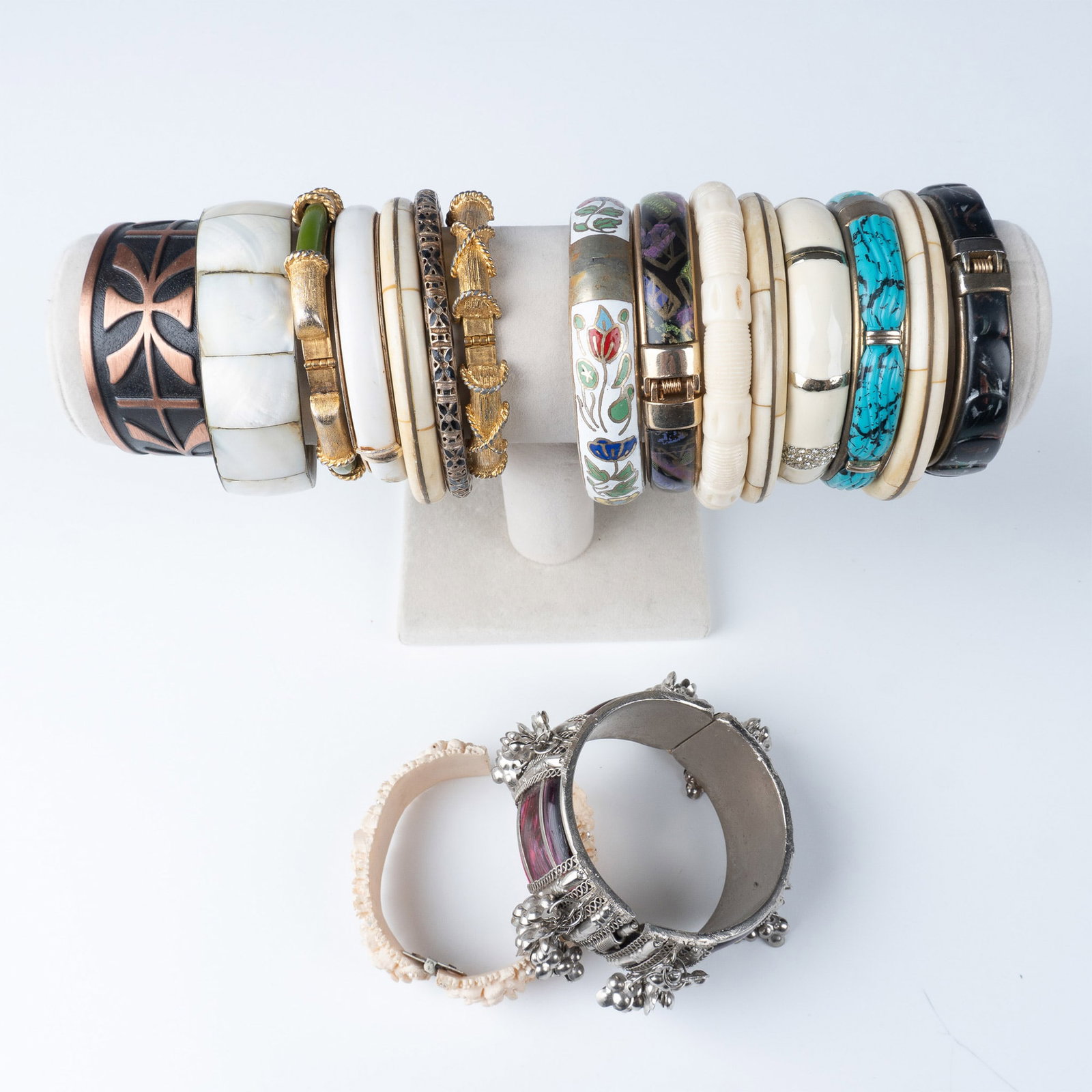 17pc Vintage Bangle Bracelets Collection: A collection of 17 vintage bangle bracelets, each featuring unique designs and materials. The assortment includes a variety of styles such as enamel, carved bone, metal, and decorative pieces with rhi