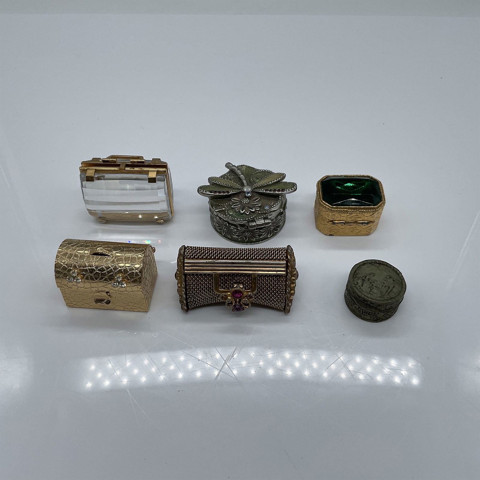 6pc Vintage Miniature Pill Boxes: A collection of six vintage miniature boxes in various styles and materials, including metal and gold-tone finishes. This lot features intricate designs such as floral and gemstone accents, with some