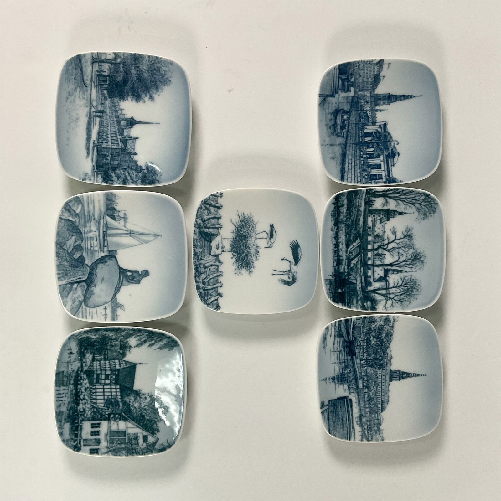 7pc Bing & Grondahl Historical Sites Collectible Trays: A set of 7 collectible mini trays by Bing & Grondahl, showcasing beautifully detailed depictions of Denmark's historical and cultural landmarks. The collection features sites such as Thorvaldsens Muse