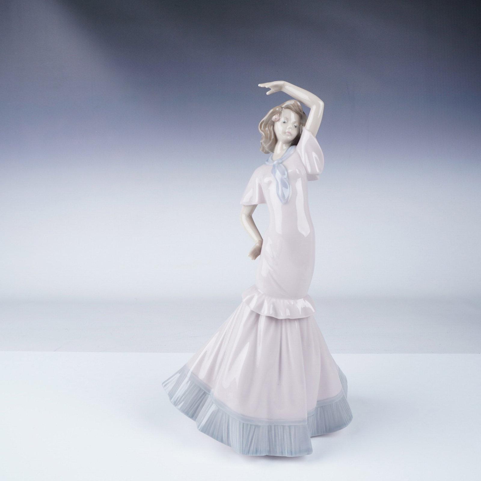 Nao by Lladro Porcelain Figurine, Flamenco Dancer: Elegant Nao by Lladro porcelain figurine depicting a graceful flamenco dancer in a flowing pastel-colored dress with ruffled details. The figurine captures movement with her poised stance and expressi