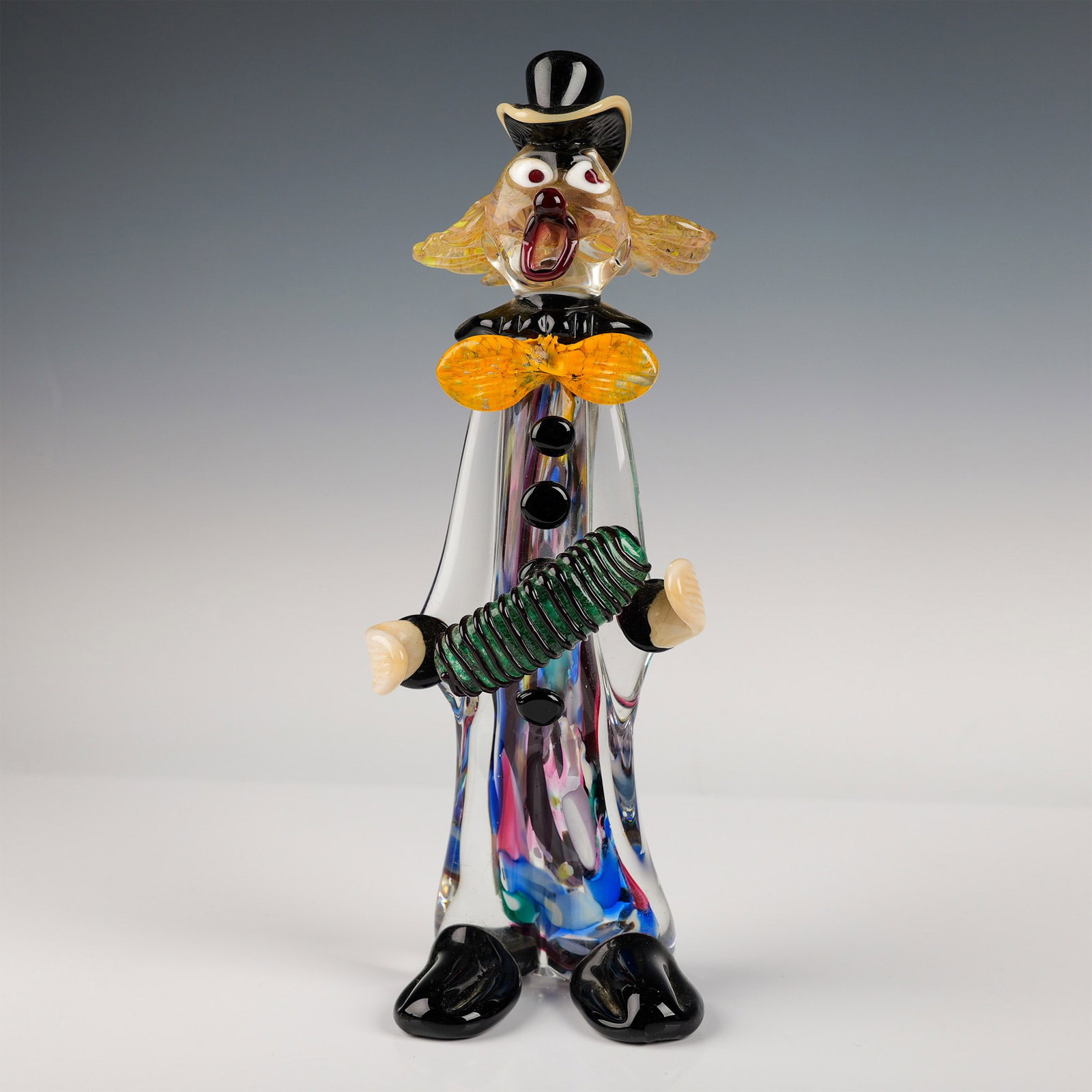 Signed Mario Sandon Murano Glass Clown Figurine: This striking Murano glass clown figurine by renowned glass artist Mario Sandon stands 13.5" in height. The piece features a colorful and playful design, showcasing vibrant hues and intricate detailin