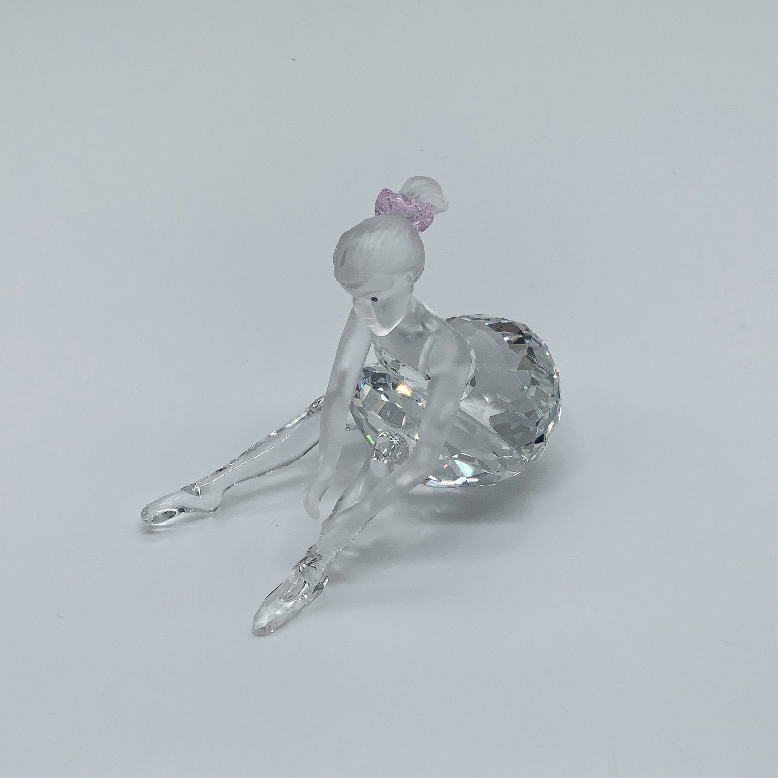 Swarovski Crystal Figurine, Young Ballerina: This Swarovski crystal figurine, designed by Edith Mair, captures a young ballerina in a poised and delicate moment. Rendered in clear and frosted crystal, the piece features a Rosaline crystal bow in
