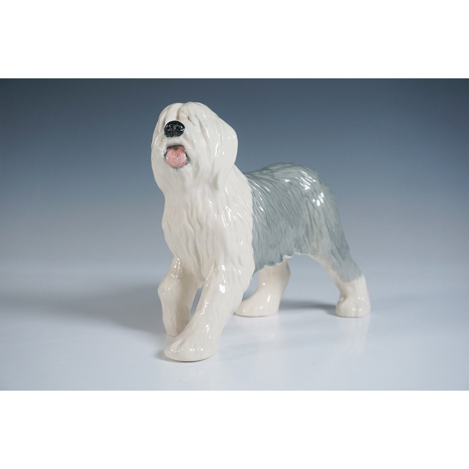 Beswick Figurine, Old English Sheep Dog - Walking D3058: This charming Beswick figurine depicts an Old English Sheep Dog in a walking pose. Crafted with exquisite detail, the piece showcases the dog's iconic shaggy coat, painted in soft gray and white tones