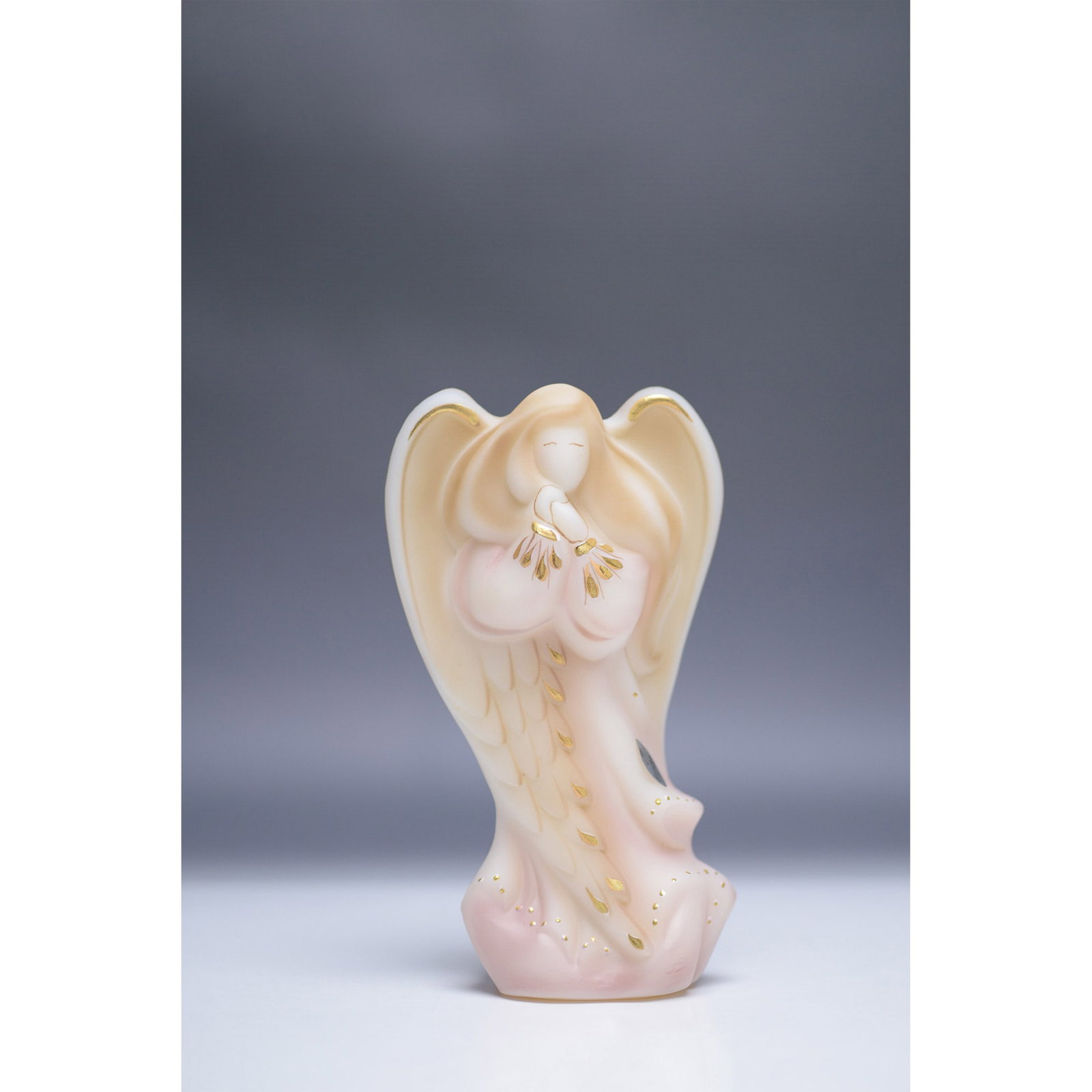 Fenton Radiant Angel Figurine: This is a limited edition Fenton Radiant Angel figurine, model number 5542HJ. Crafted in a delicate blend of soft pink and cream hues, the figurine features gold accents highlighting the angel's wings