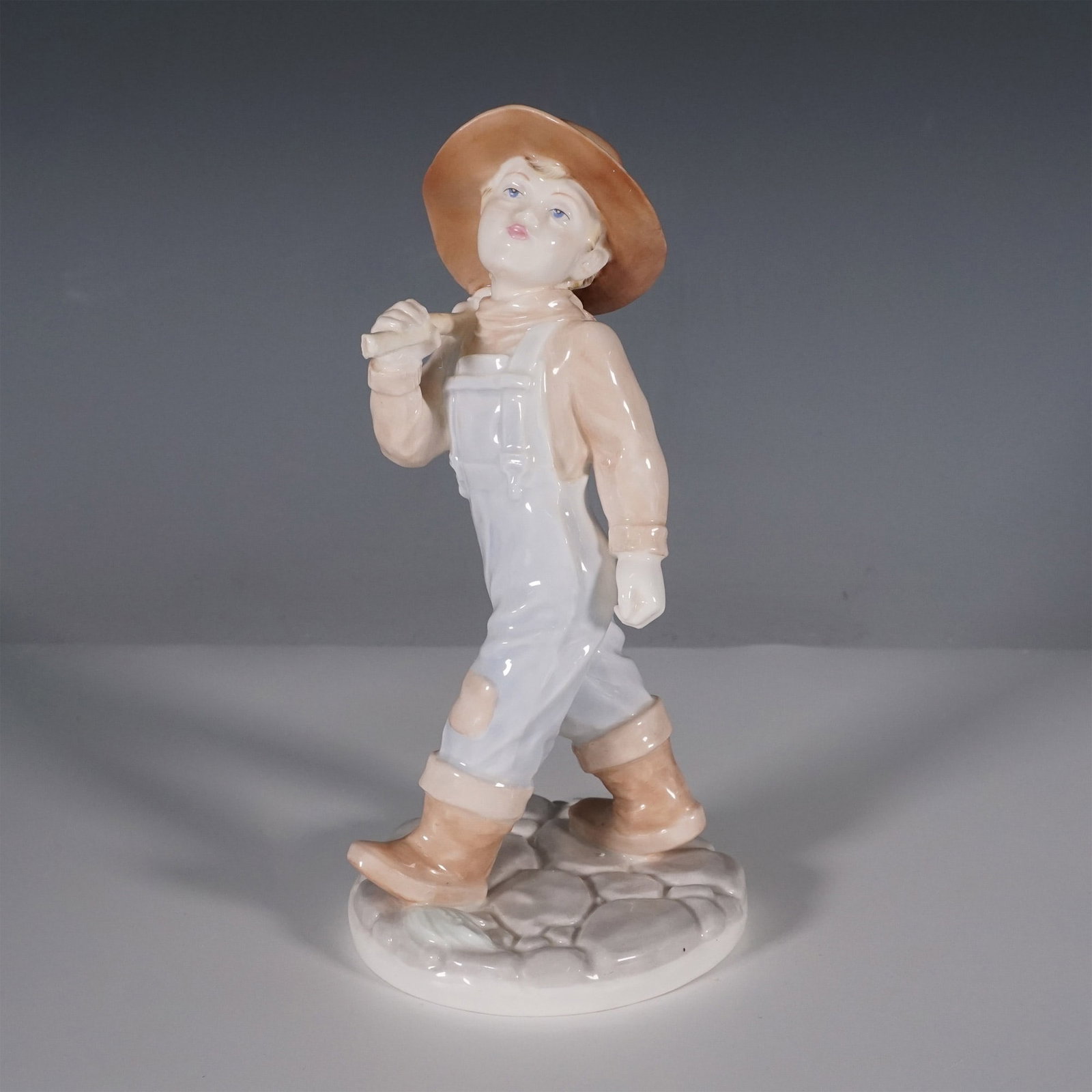 Coalport Bone China Figurine, Thursdays Child Has Far to Go: Coalport fine bone china figurine titled Thursdays Child Has Far to Go, designed by John Bromley. This intricately crafted figurine portrays a young boy in overalls and a wide-brimmed hat, confidently