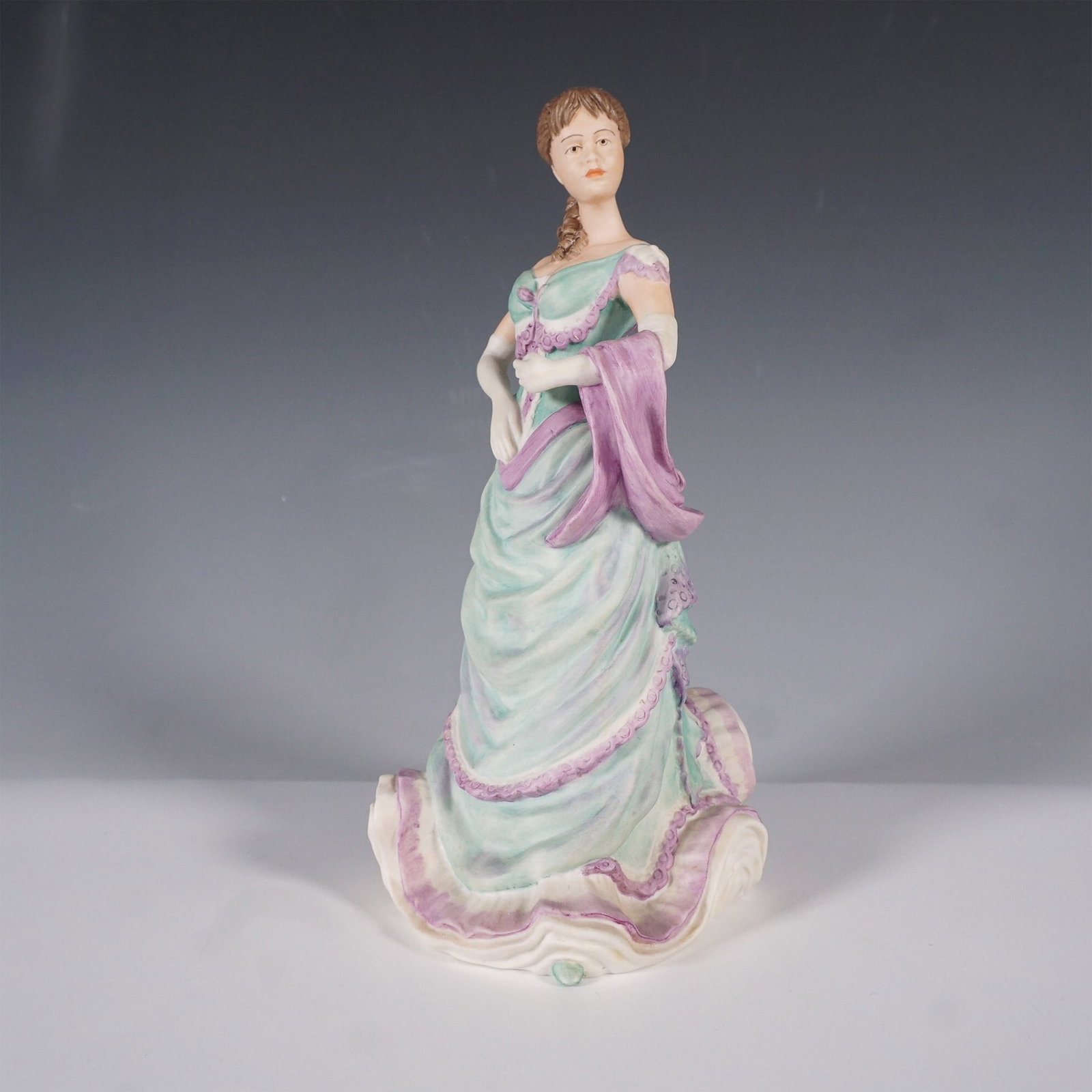 Coalport Age of Elegance Afternoon Matinee Figurine: Exquisite Coalport porcelain figurine titled Afternoon Matinee from the Age of Elegance collection. This finely crafted piece showcases a graceful Victorian-era lady dressed in a flowing pastel green 