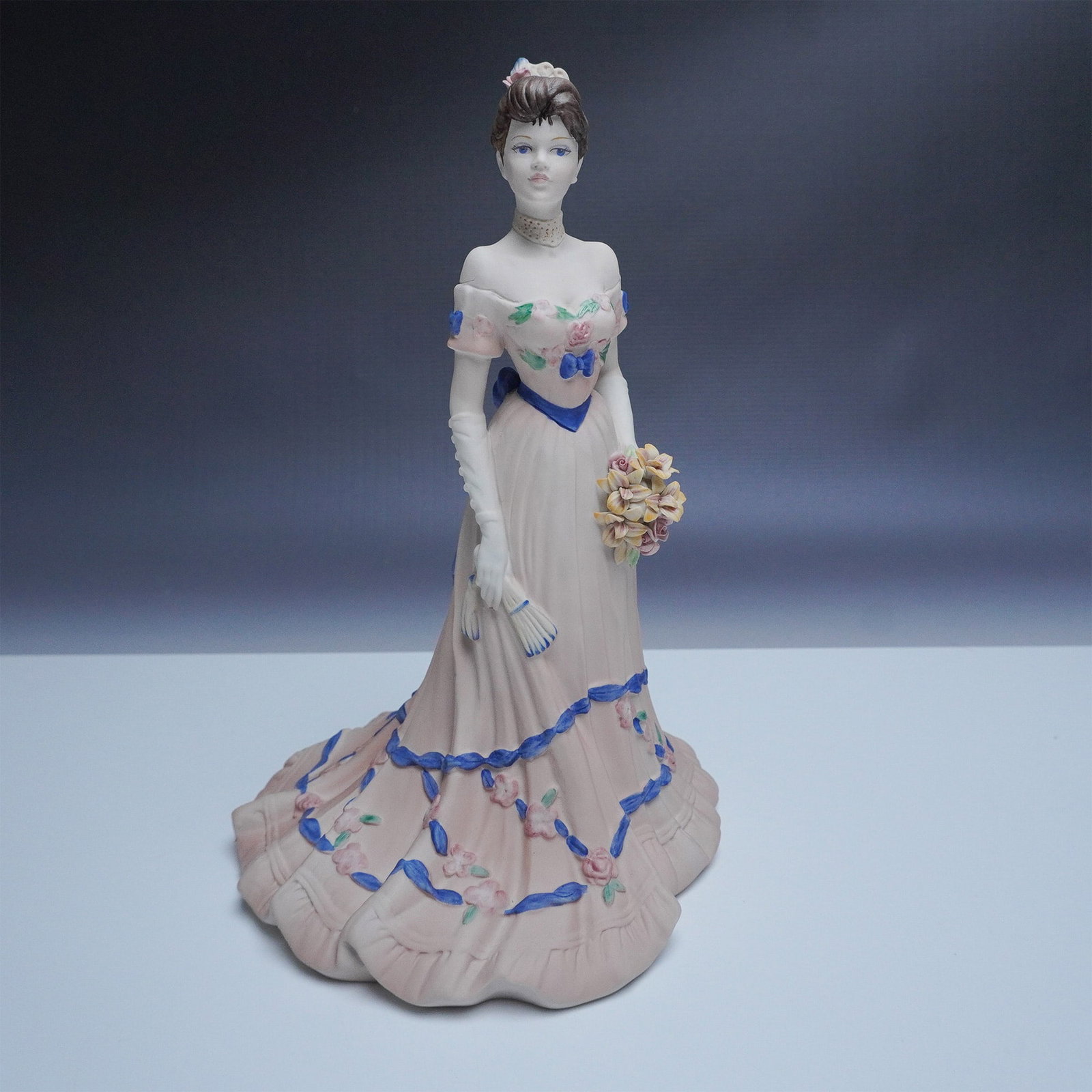 Coalport Age of Elegance Magnolia Parade Figurine: This elegant Coalport fine bone china figurine, titled Magnolia Parade, is part of the Age of Elegance collection. Hand-decorated and modelled by artist Jack Glynn, this figurine portrays a graceful l