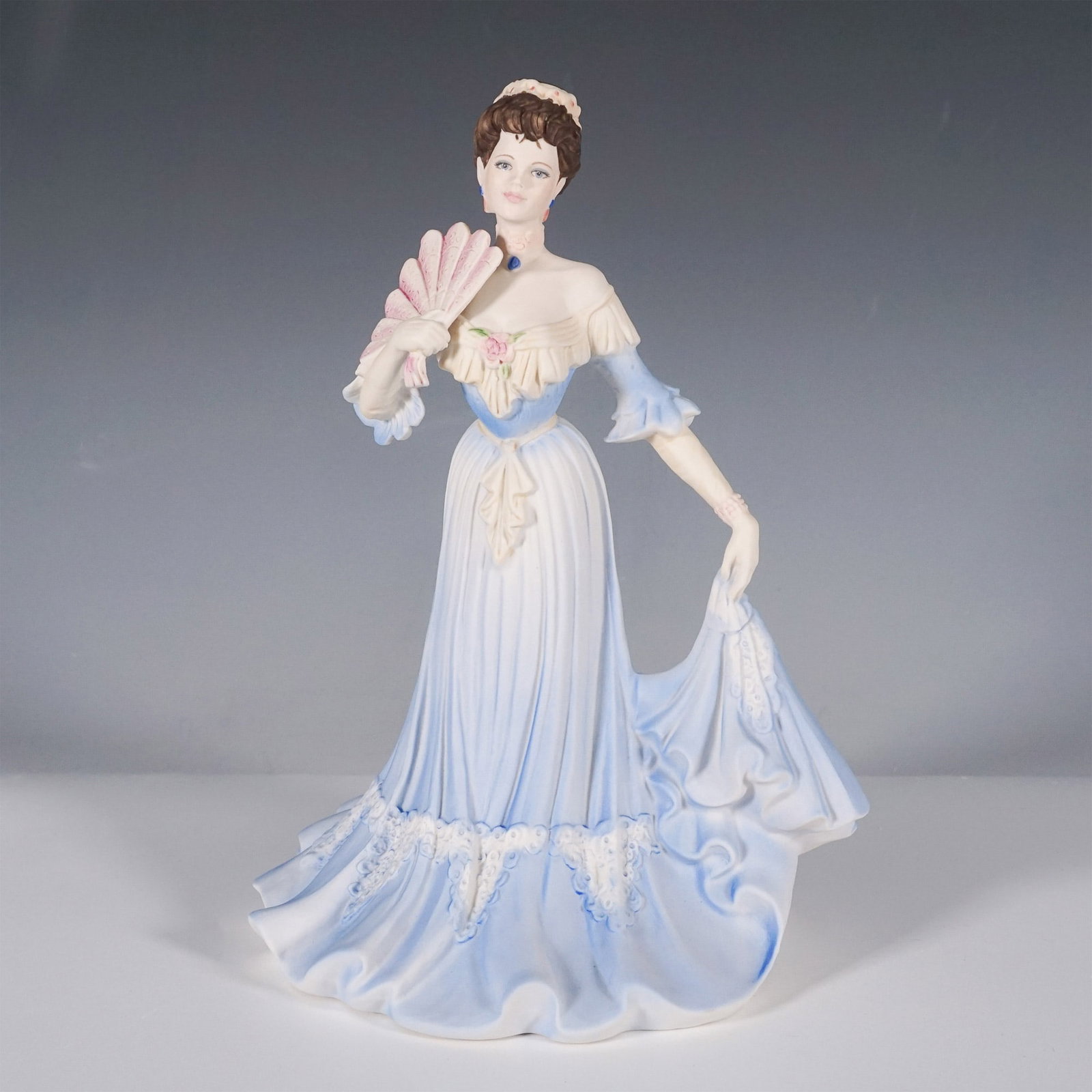 Coalport Age of Elegance Figurine, Royal Invitation: A finely crafted Coalport porcelain figurine from the esteemed Age of Elegance collection. This elegant piece was the Figurine of the Year 1998 and features a poised lady in a flowing blue gown with d