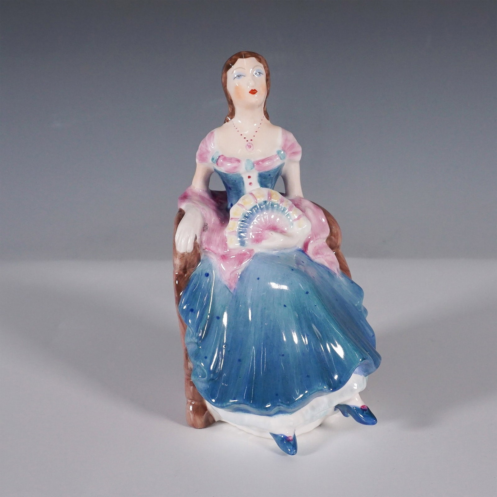 Coalport Porcelain Figurine, Barbara: The Coalport Barbara figurine is a beautifully crafted porcelain piece that exudes elegance and refinement. Made in England from fine bone china, this exquisite collectible features a seated lady dres