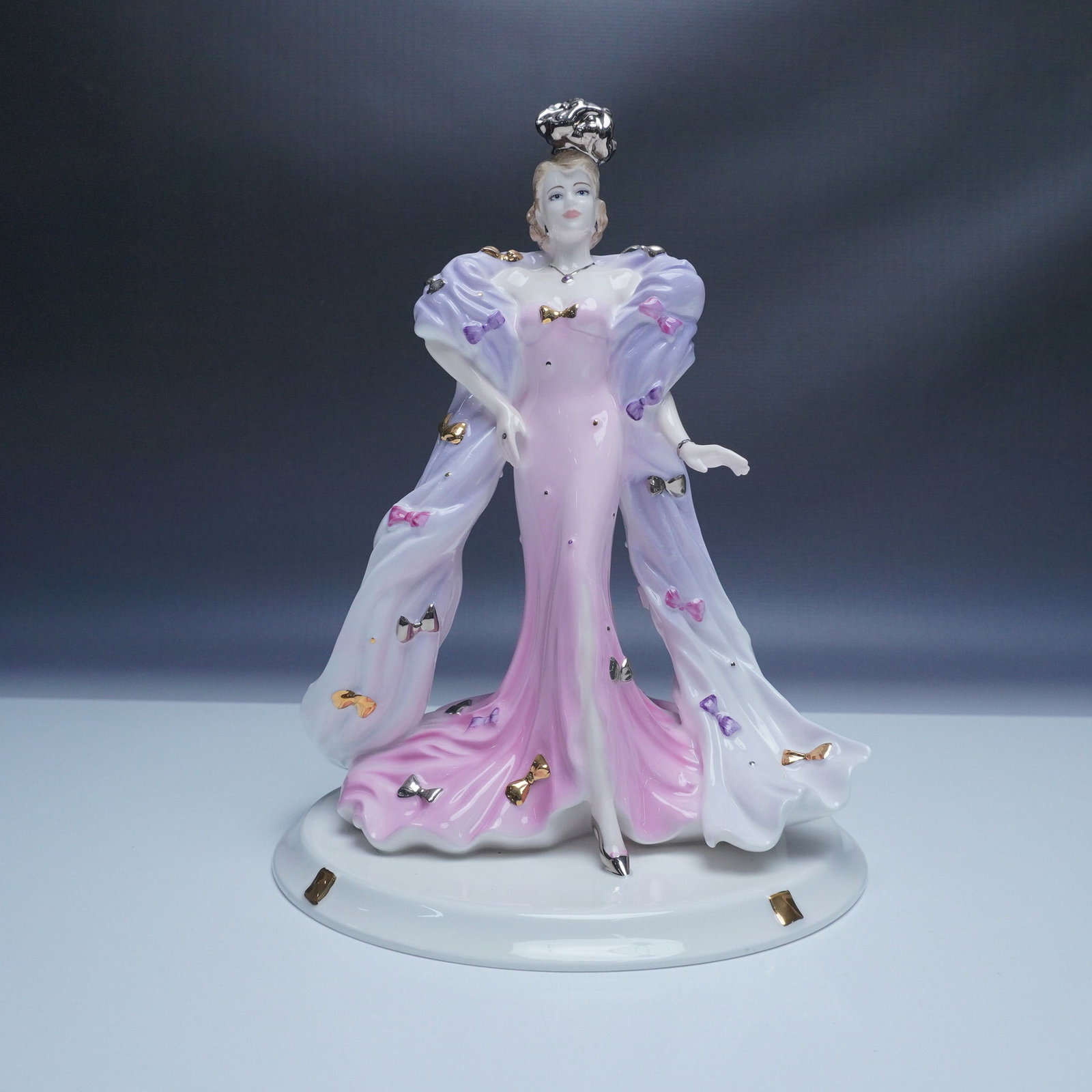 Coalport David Shilling Celebration Coll. Bow Belle Figurine: A striking Coalport bone china figurine titled Bow Belle, part of the David Shilling Celebration Collection. Designed by renowned milliner and designer David Shilling and modeled by Jack Glynn, this f