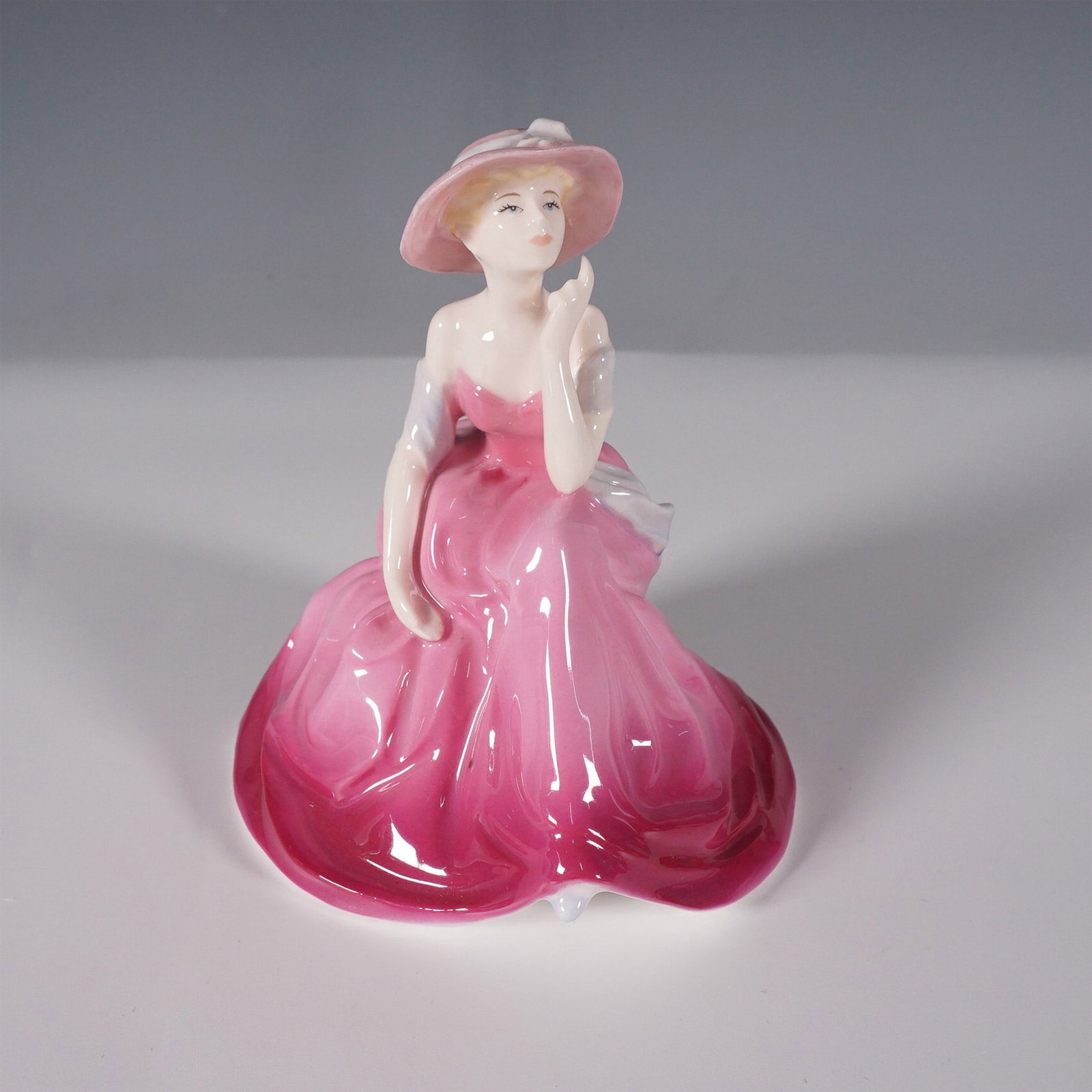 Coalport Debutantes In Love Figurine: Charming Coalport figurine titled In Love, from the Debutantes collection. This elegant 1989 bone china figurine captures a young lady seated gracefully on a bench, lost in thought. She is dressed in 