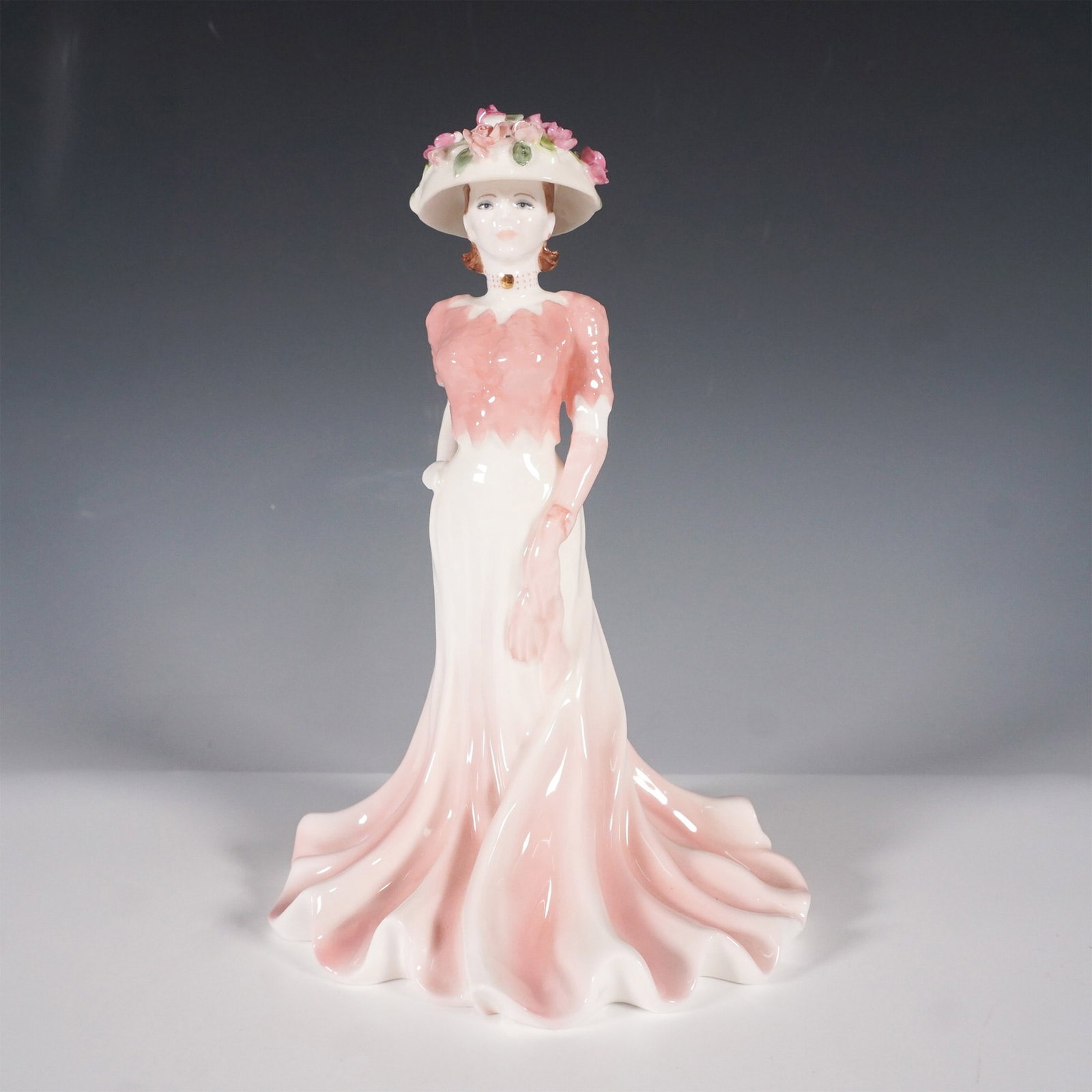 Coalport Ladies of Fashion Figurine, Liz: Part of the Ladies of Fashion collection, this elegant bone china figurine captures the timeless grace of Victorian-era style. Designed by Jenny Oliver, the figure depicts a refined woman in a flowing