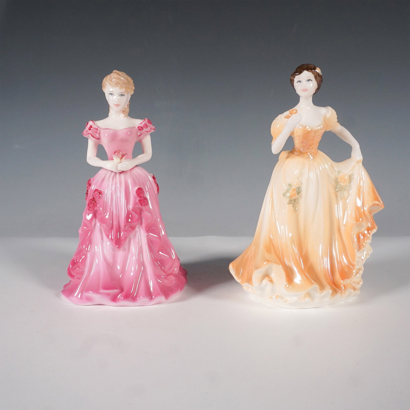 2pc Coalport Debutante Year Figurines Rose Ball & Dawn: This pair of exquisite Coalport bone china figurines from the Debutante of the Year series includes Rose Ball (1995) and Dawn Summer Ball (1996). Rose Ball was created to commemorate the Alexandra Ros