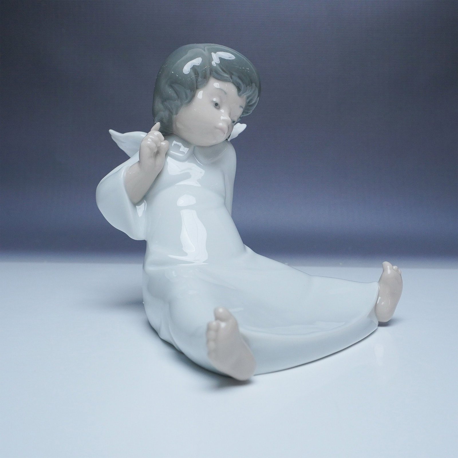Lladro Porcelain Figurine, Wondering Cherub 01004962: This charming Lladro porcelain figurine, titled Wondering Cherub (01004962), captures the innocence and curiosity of a young angel. Designed with delicate features and a serene expression, this piece 