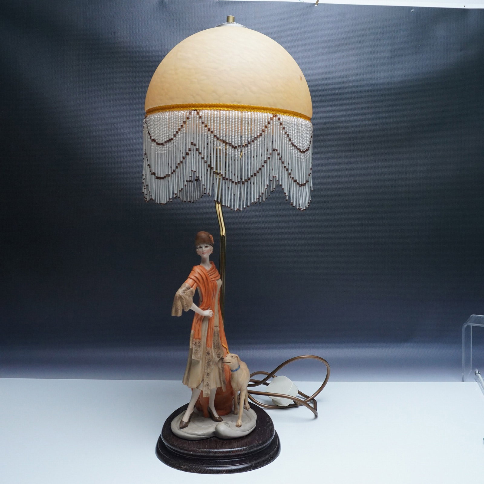 Art Nouveau Figural Lamp with Beaded Shade: An exquisite Art Nouveau-style figural lamp featuring a gracefully posed woman in an elegant flowing gown, accompanied by a greyhound. The finely detailed sculpture captures the organic, fluid aesthet