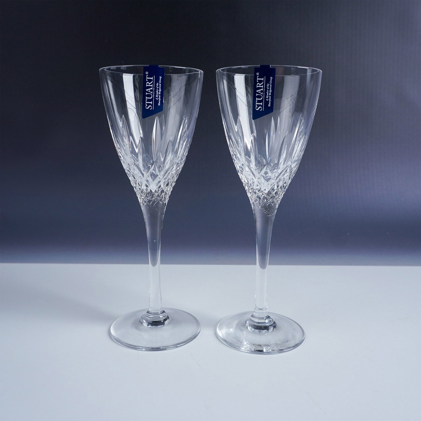 Pair of Stuart Crystal Cut Glass Wine Glasses, Madison: This elegant set of two cut glass wine glasses is crafted by Stuart Crystal, a prestigious British glass manufacturer established in 1827 and renowned for its high-quality crystal glassware. Each glas