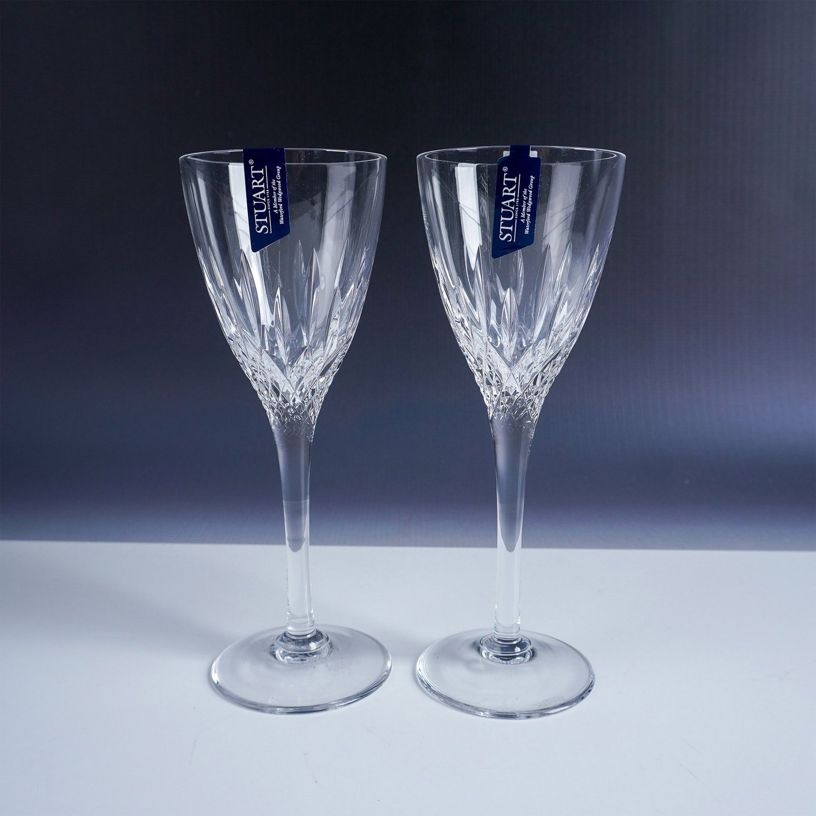 Pair of Stuart Crystal Cut Glass Wine Glasses, Madison: This elegant set of two cut glass wine glasses is crafted by Stuart Crystal, a prestigious British glass manufacturer established in 1827 and renowned for its high-quality crystal glassware. Each glas