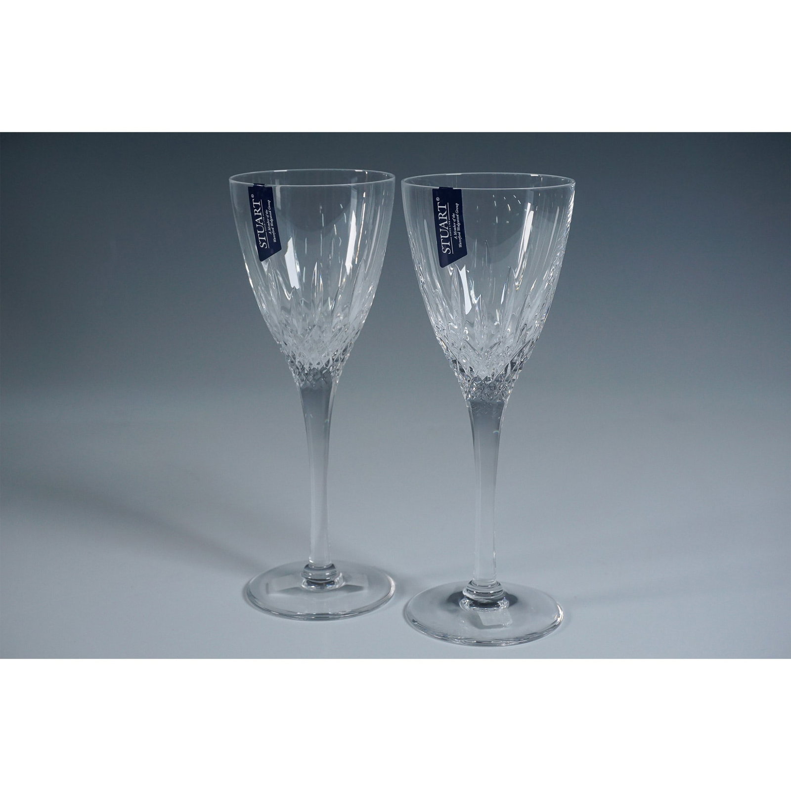 Pair of Stuart Crystal Wine Glasses, Madison: A pair of Stuart Crystal wine glasses in the elegant Madison design. Crafted in Great Britain, these glasses feature a stunning cut criss-hatch pattern on the bowls, showcasing the brand's exceptional