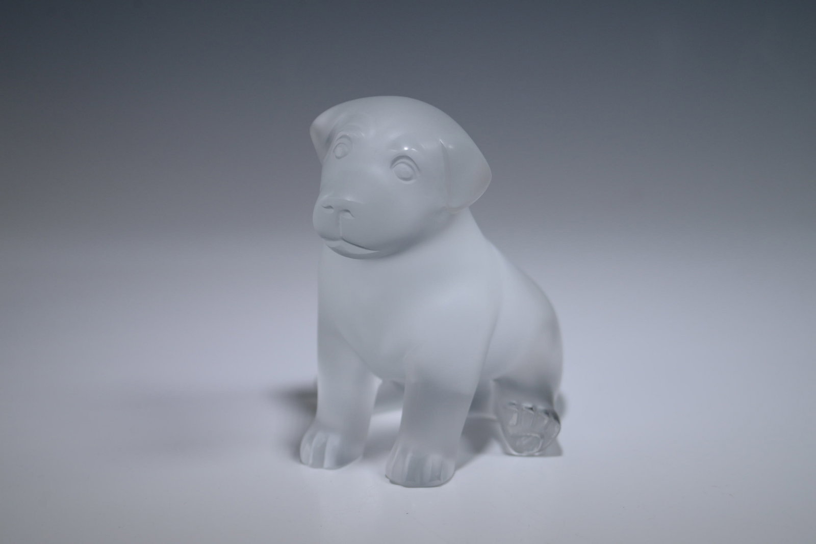 Lalique Crystal Sitting Puppy, Clear Crystal: This exquisite Lalique Crystal Sitting Puppy is crafted from clear crystal, capturing the playful nature of a young puppy in a beautifully detailed design. Measuring 5.11 inches tall. This piece is a 