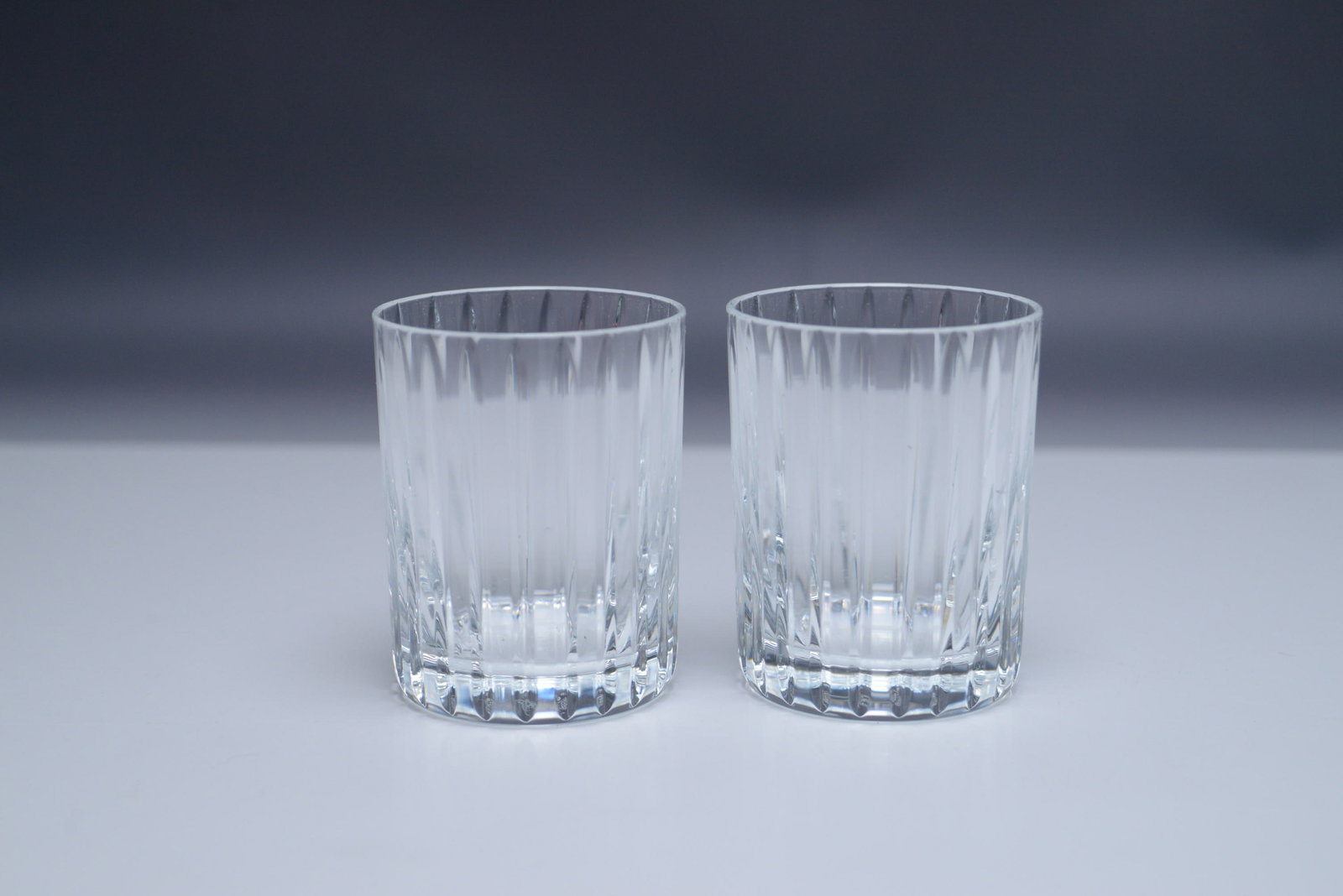 Baccarat Crystal Harmonie Tumbler Set, Original Box: This set of two Baccarat Harmonie tumblers from the esteemed Harmonie collection is crafted from premium clear Baccarat crystal, renowned for its brilliance and clarity. The tumblers feature elegant p