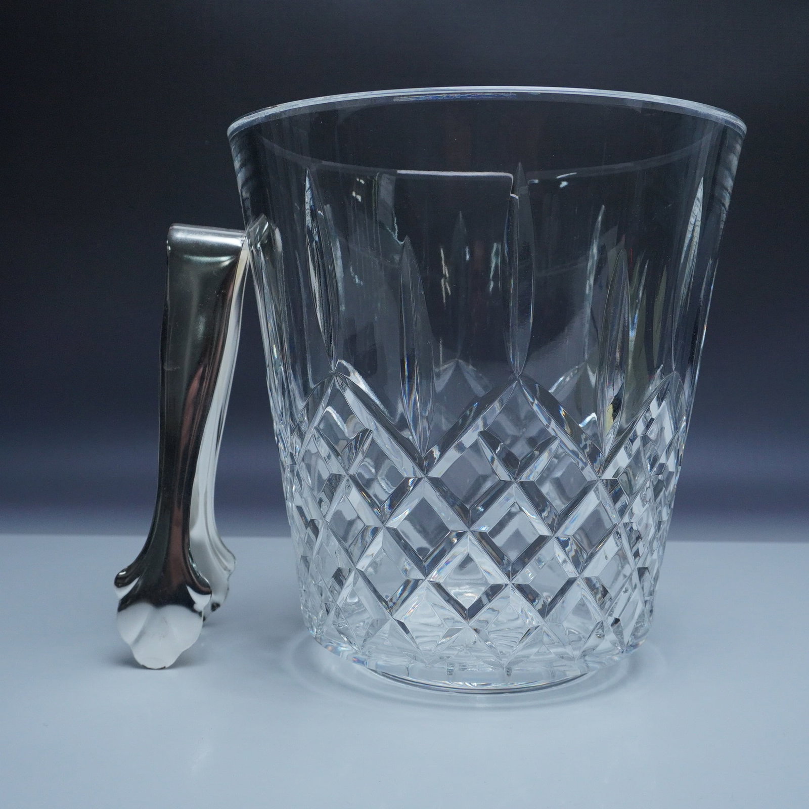 Waterford Crystal Ice Bucket with Tongs, Killarney Pattern: This stunning Waterford crystal ice bucket showcases the elegant Killarney pattern, featuring intricate diamond cuts that shimmer in the light. The bucket is designed with a sleek, modern shape and is