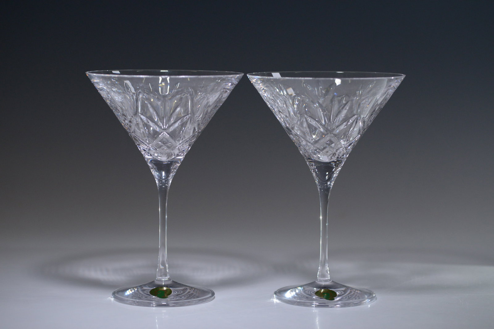 Pair of Waterford Crystal Huntley Martini Glasses: A pair of Waterford Crystal Huntley Martini Glasses featuring a sophisticated design. The Huntley pattern is characterized by an elegant mix of vertical and crisscross cuts, creating a striking geomet
