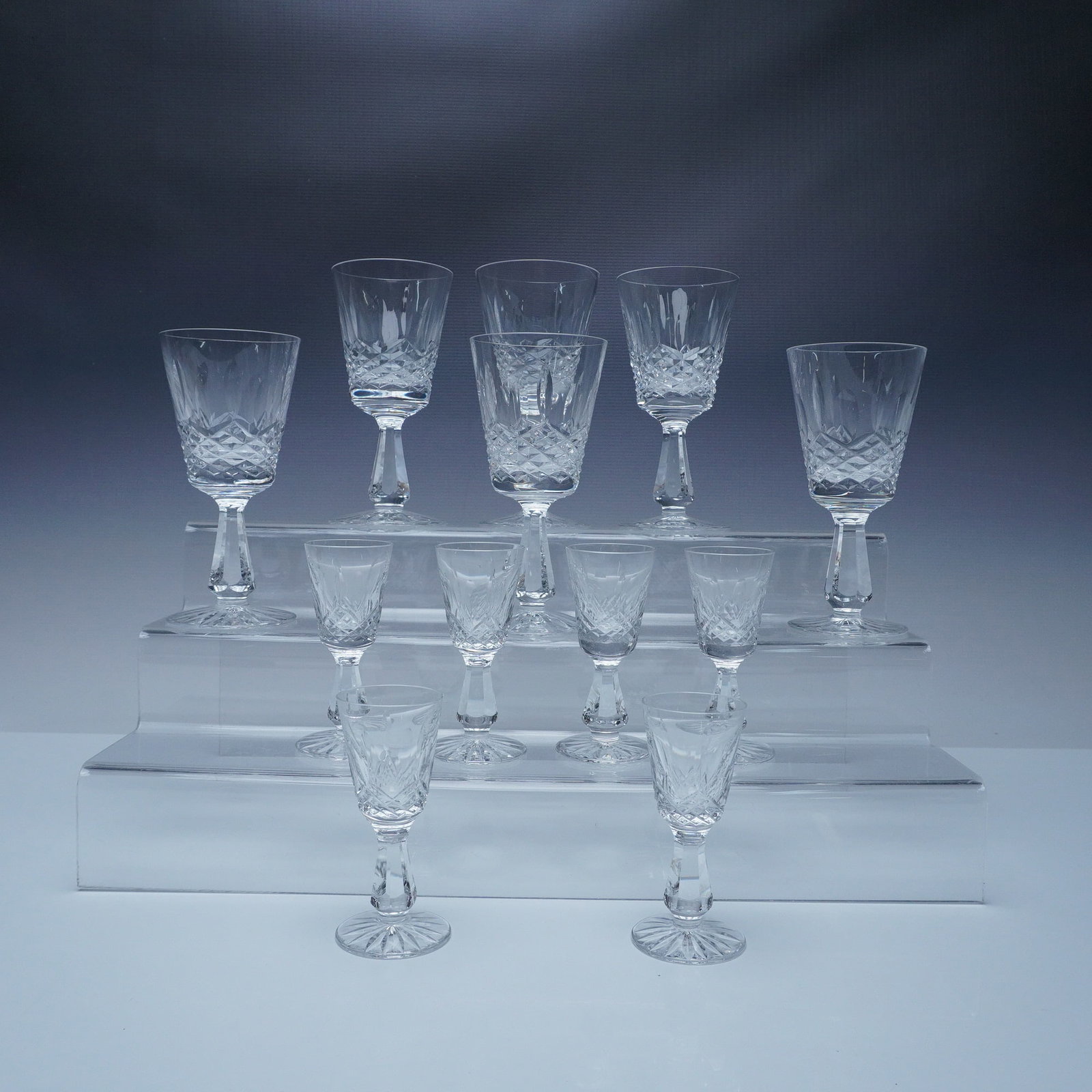 12pc Waterford Crystal Cordial and Sherry Glasses, Lismore Pattern: A set of twelve Waterford crystal cordial and sherry glasses in the timeless Lismore pattern, featuring elegant diamond and wedge cuts. The tallest piece measures 6"H. The Lismore pattern, introduced 