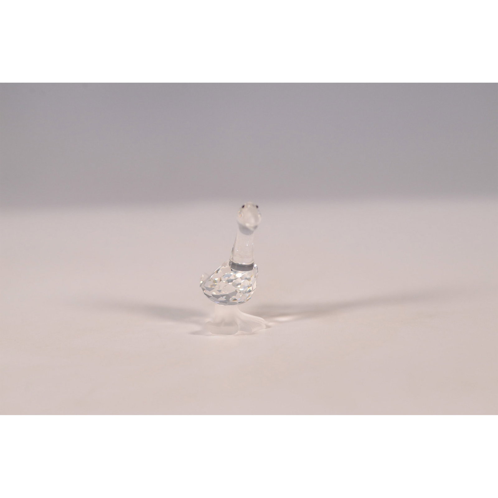 Swarovski Crystal Figurine, Gosling Tom 174961: This Swarovski crystal figurine, Gosling "Tom" (item number 174961), was designed as part of the Barnyard Friends collection. This charming figurine features a clear faceted crystal body with frosted 