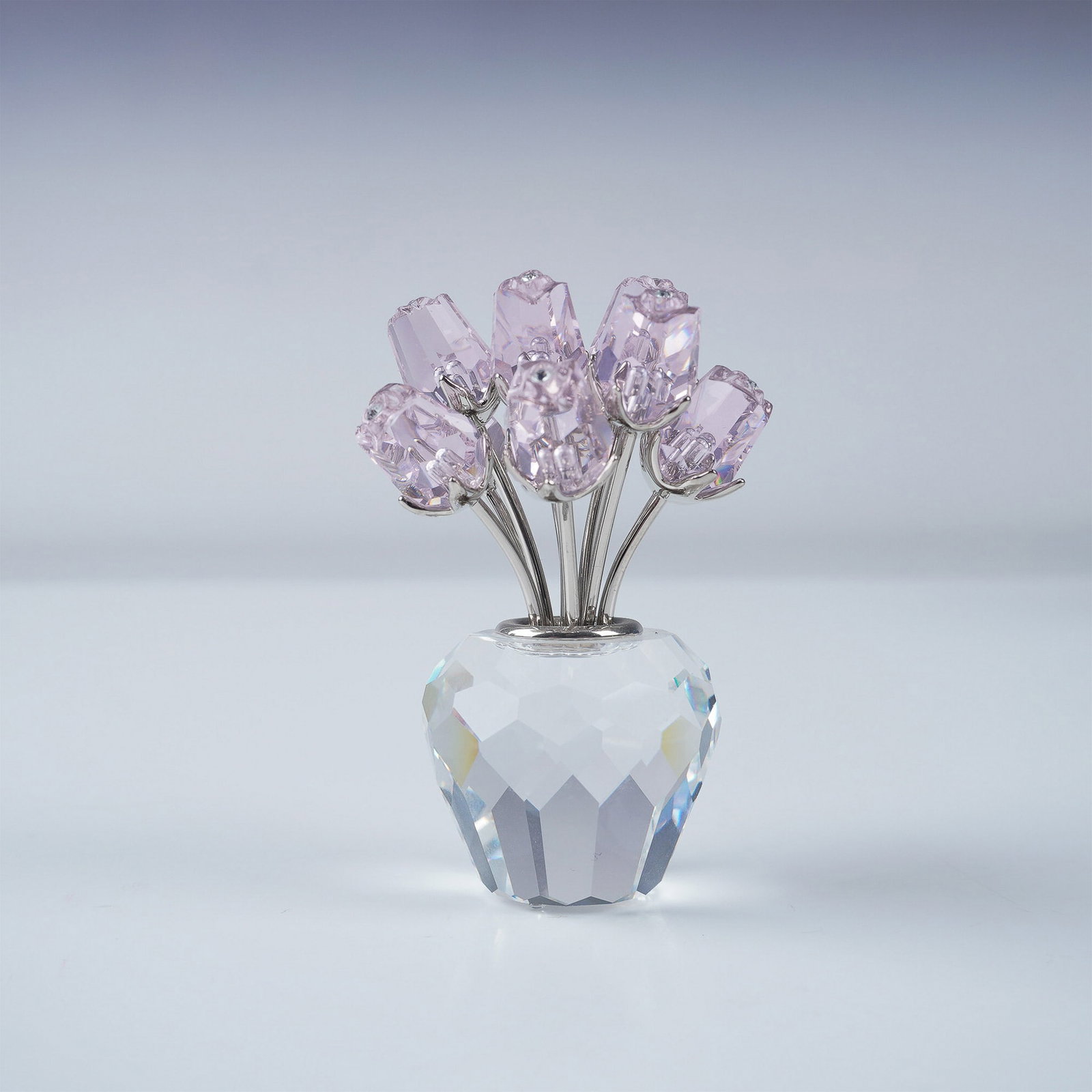 Swarovski Crystal Figurine, A Dozen Pink Roses: Part of the In the Secret Garden collection, this exquisite Swarovski crystal figurine features a vase of a dozen pink roses. The vase is crafted from faceted clear crystal, complemented by rhodium-pl