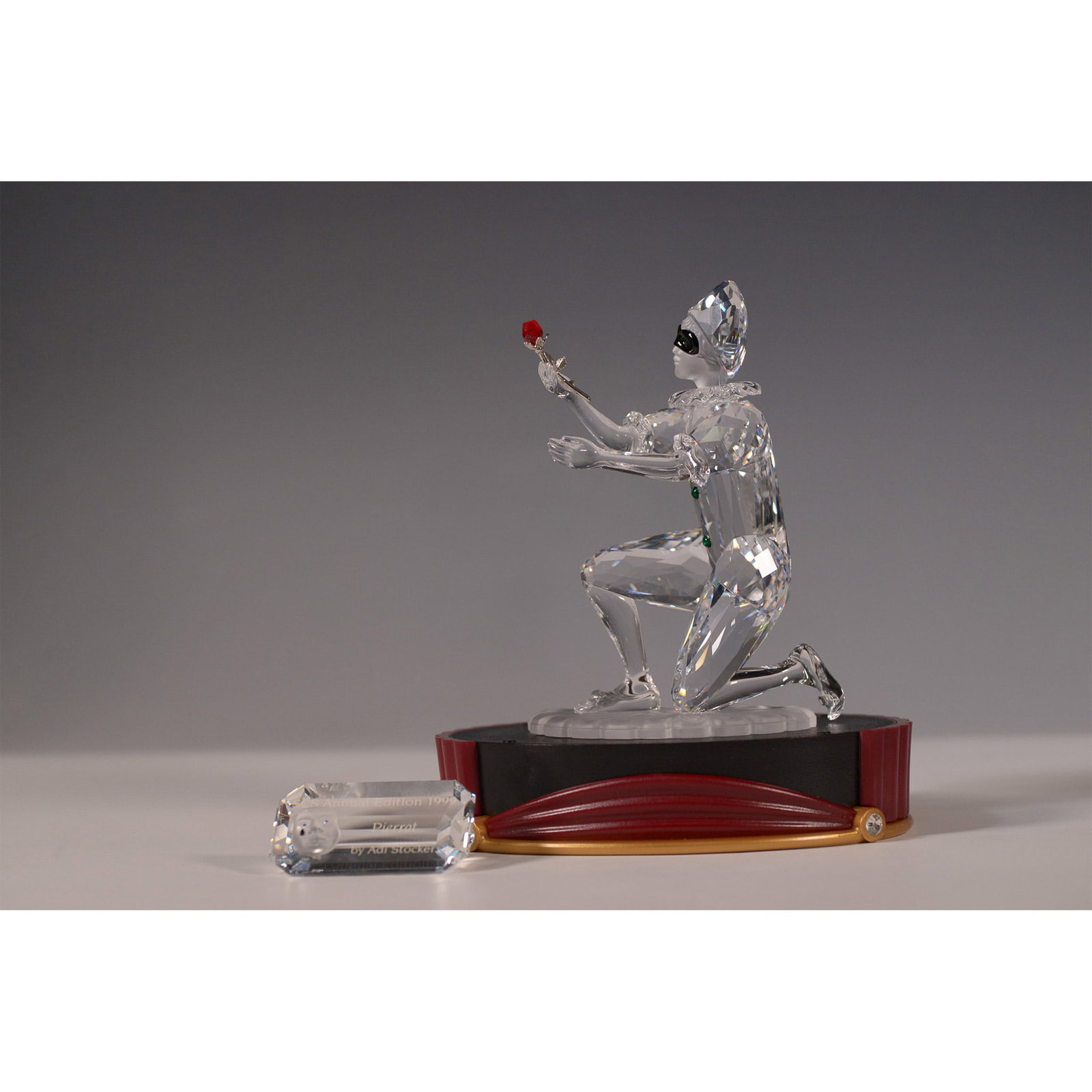 2pc Swarovski Annual Edition 2001 Figurine, Harlequin 254044: Designed by Anton Hirzinger, Harlequin is the final piece in the Masquerade trilogy, following Pierrot (1999) and Columbine (2000). Crafted from clear, frosted, and black crystal, it features a red cr
