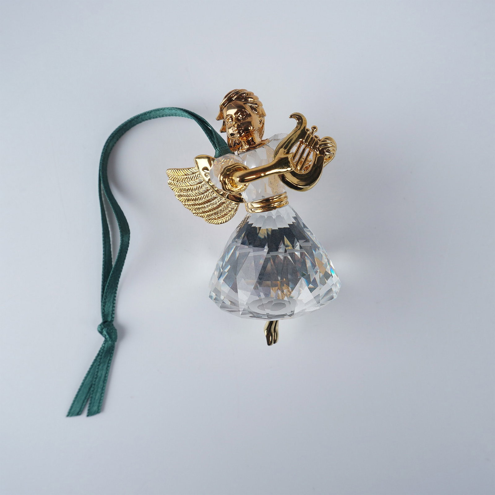 Swarovski Crystal Ornament, 1998 Angel: The Swarovski 1998 Angel is the third in a limited edition series from the Christmas Memories range. This exquisite ornament features a faceted crystal body with gold-plated head, wings, arms, and har