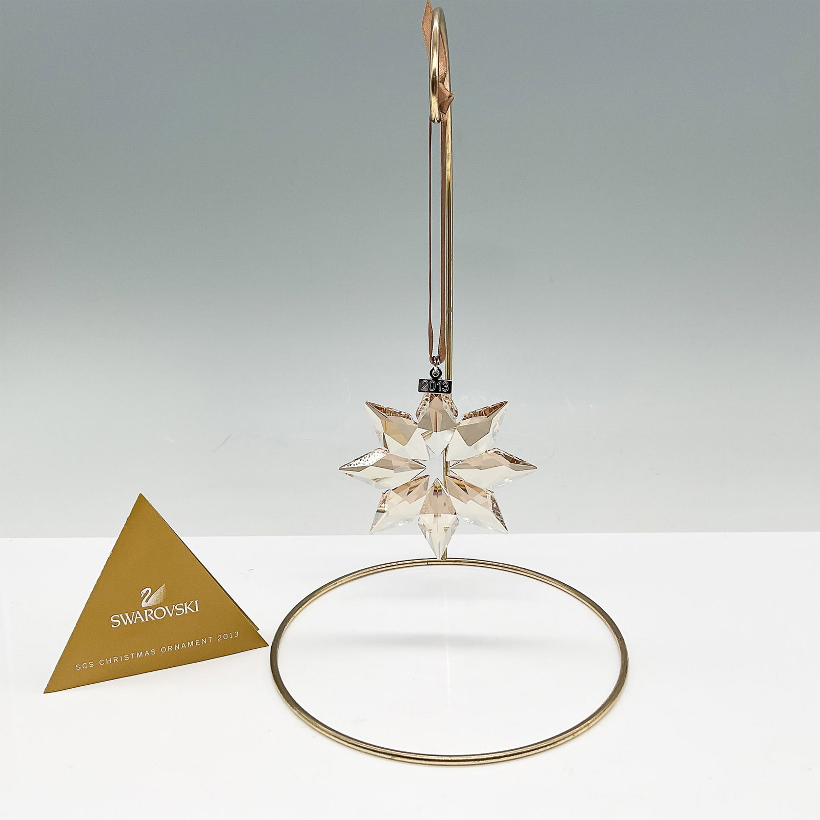 Swarovski SCS Christmas Ornament 2013 with Original Box: Limited edition Swarovski SCS Christmas Ornament from 2013, featuring a beautifully faceted golden-hued crystal star with intricate detailing. This exclusive design was available only to Swarovski Cry