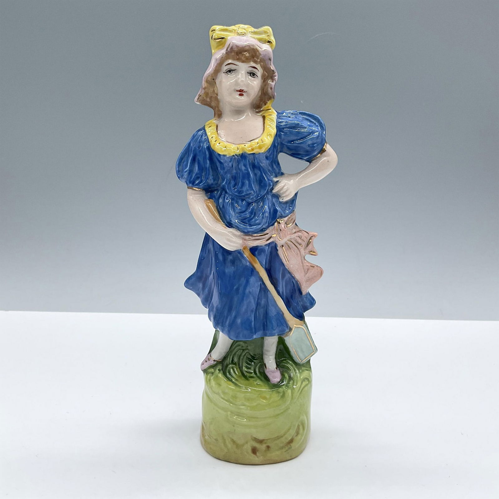 Vintage Capodimonte Style Gilded Porcelain Figurine, Maid: Glazed finish. Beautifully modeled in vibrant blue and yellow colors in an intricate decorated green base, all accented by gilt details. Dimensions: 2.25''L x 3''W x 8.25''H