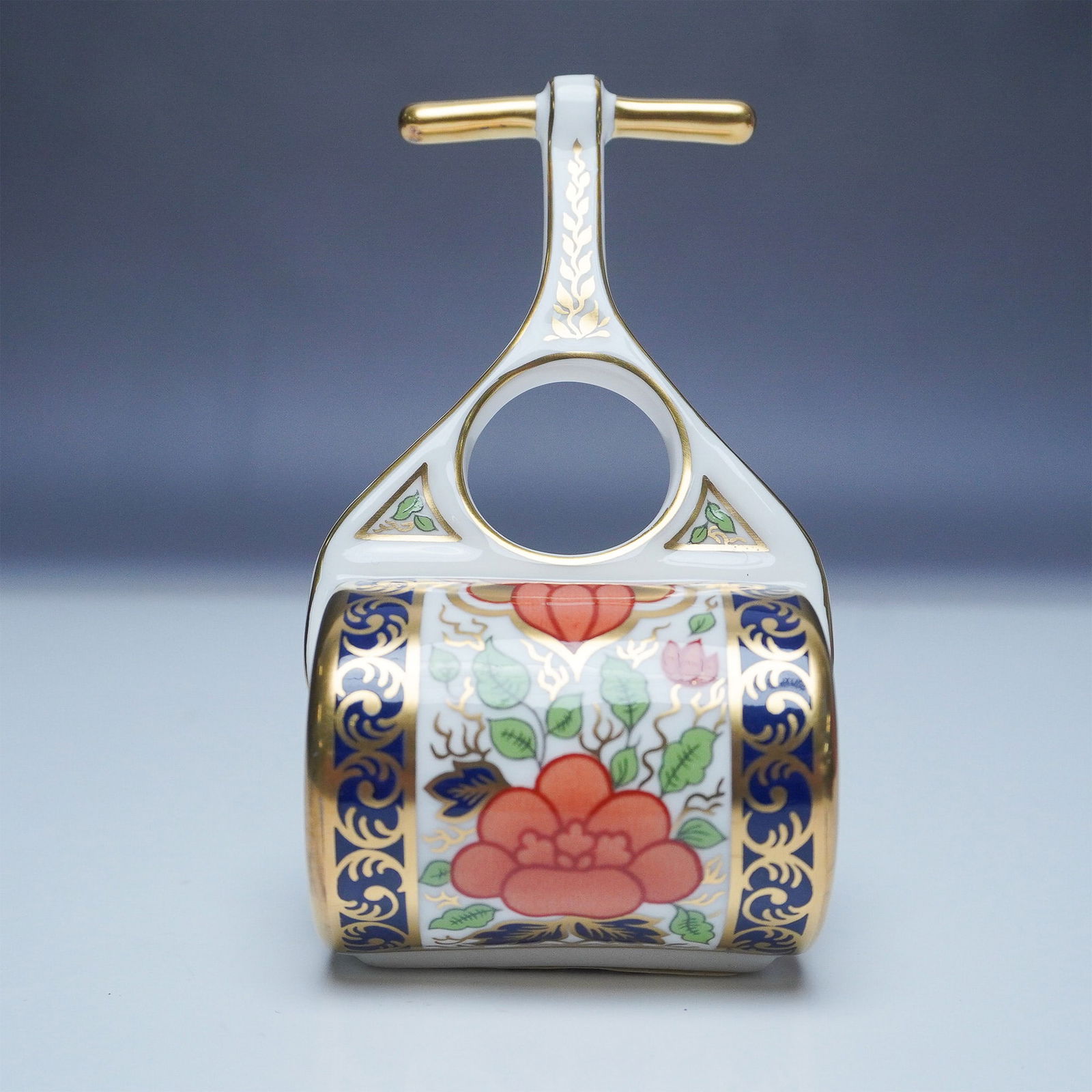 Royal Crown Derby Mini Garden Roller Figurine: This exquisite Royal Crown Derby Mini Garden Roller figurine showcases the intricate Lotus Blossom pattern, adorned with vibrant floral motifs, deep cobalt blue accents, and lavish 22K gold detailing.