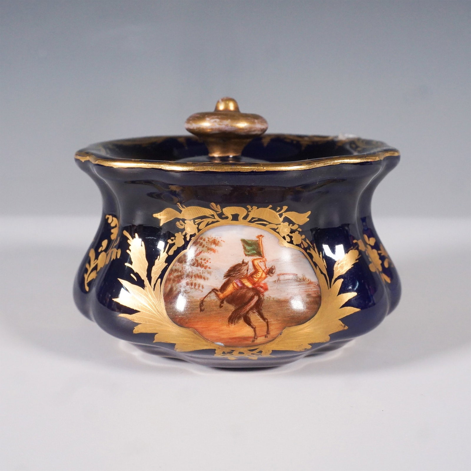 Meissen Hand-Painted & Gilded Porcelain Lidded Inkwell: This exquisite Meissen hand-painted porcelain lidded inkwell features a cobalt blue base with gold leaf detailing and a finely executed equestrian scene. The artwork, which depicts a rider on horsebac