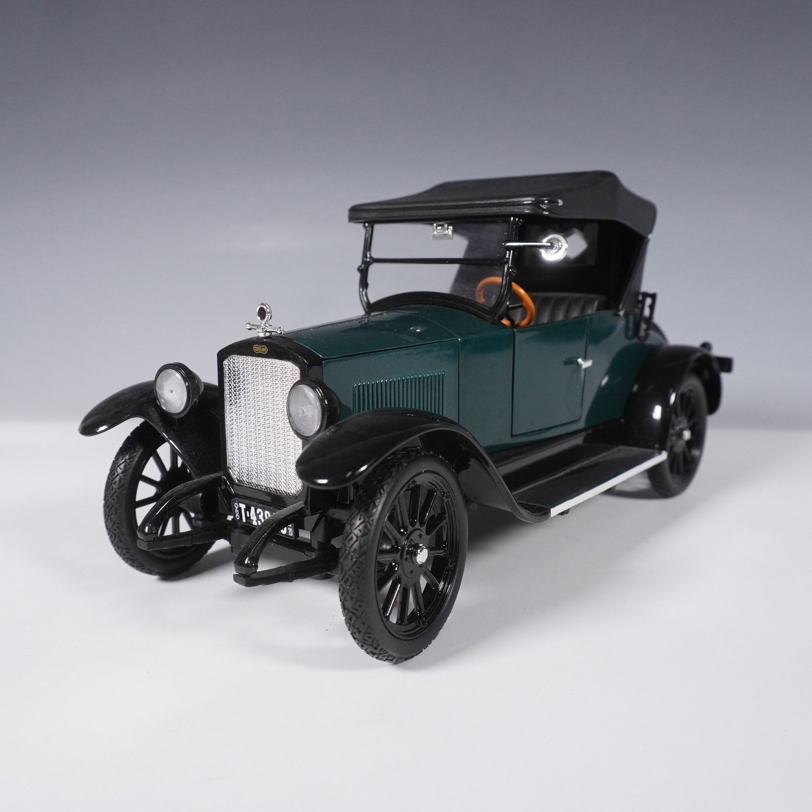 Signature Models 1:18 1920 Chevrolet Roadster Diecast Model: A finely crafted 1:18 scale diecast model of the 1920 Chevrolet Roadster by Signature Models. This highly detailed replica features a deep green body with black fenders, a black folding top, spoked wh
