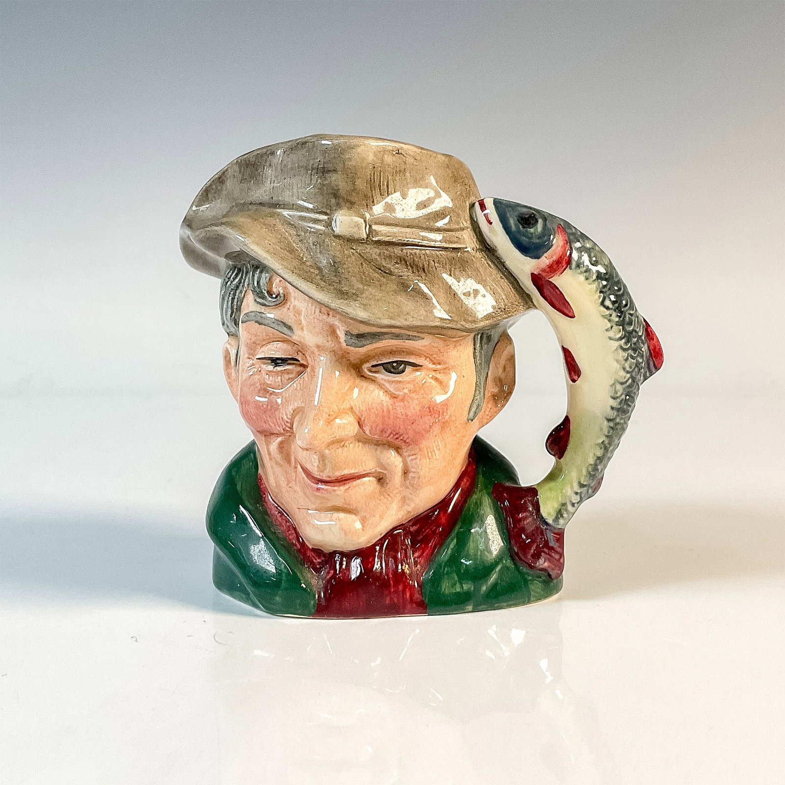 Poacher D6464 - Small - Royal Doulton Character Jug: Variation One. Green coat; red scarf; light brown hat. Royal Doulton backstamp. Artist: Max Henk Issued: 1957 - 1995 Dimensions: 4"H Country of Origin: England
